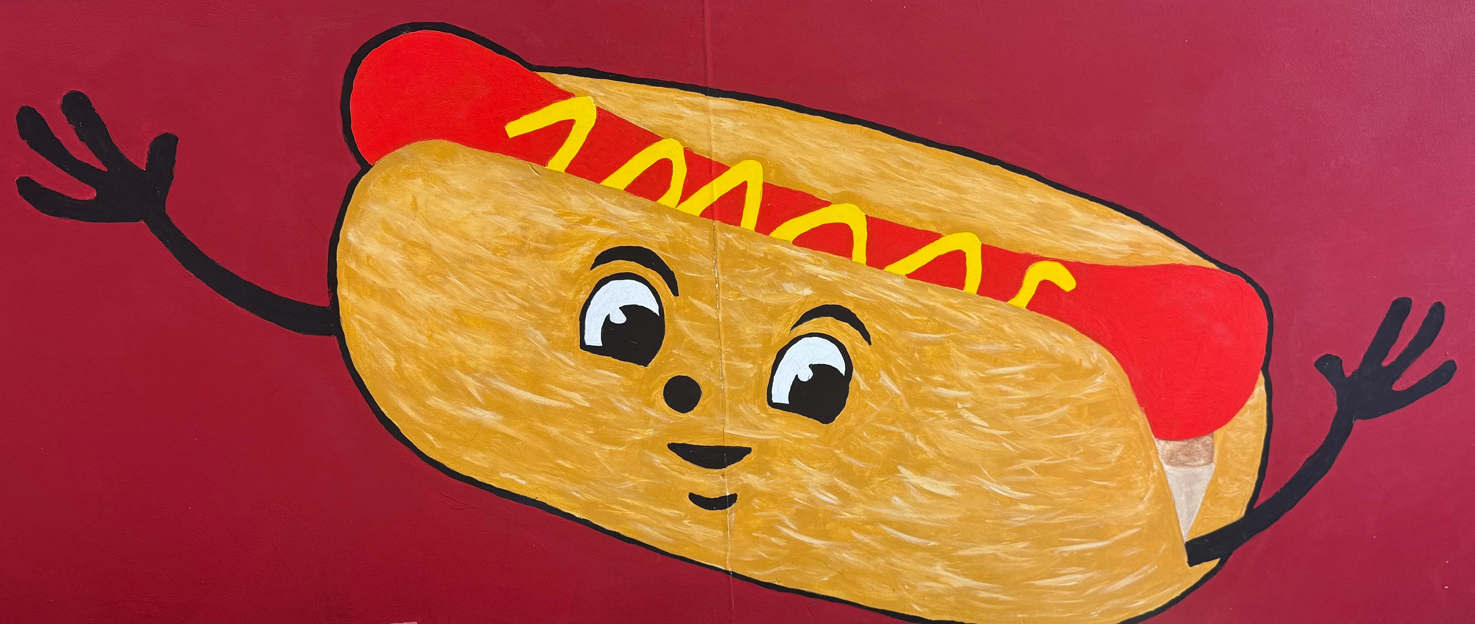 Playful cartoon hot dog character on a red background