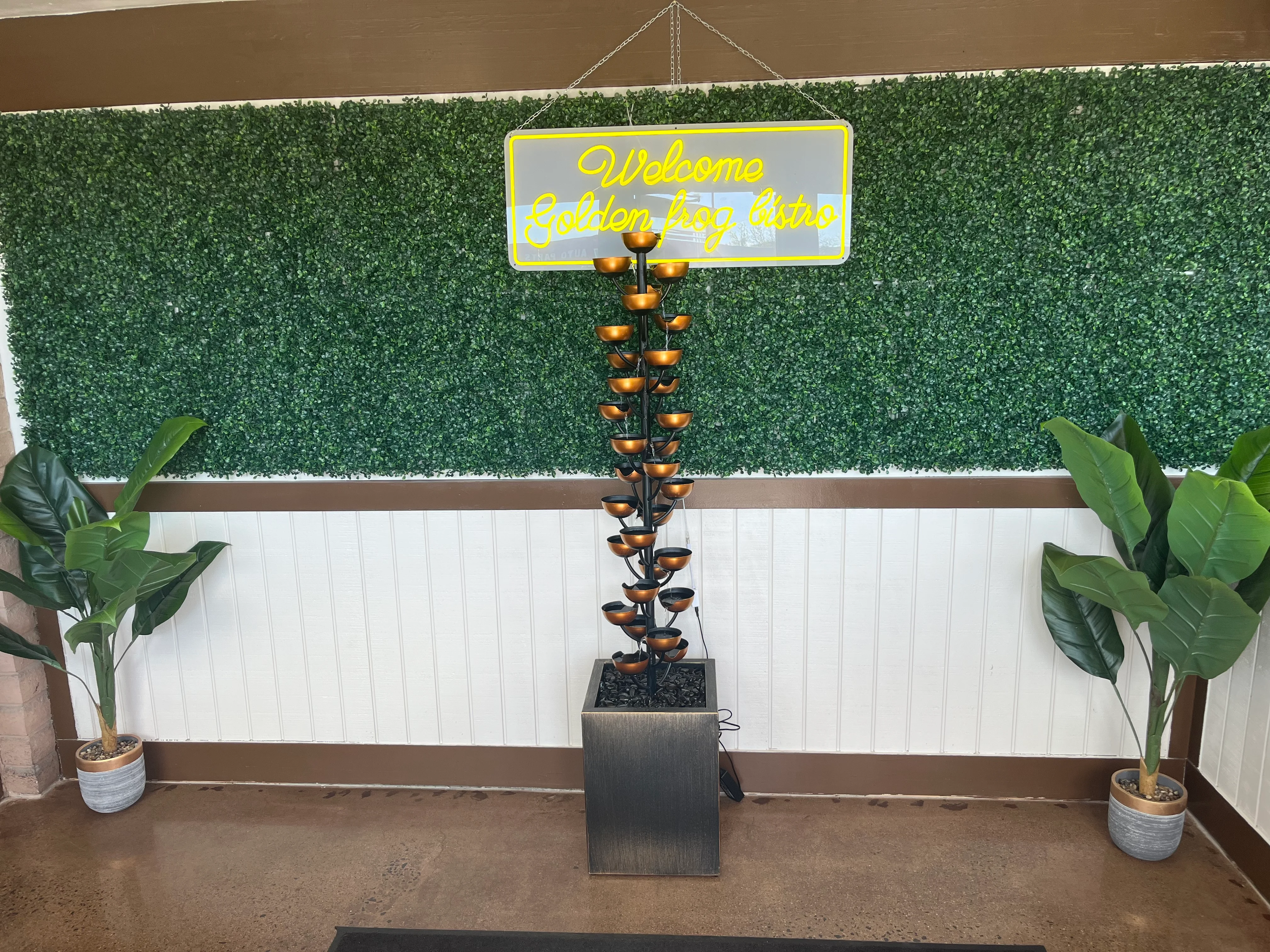 Welcoming restaurant entrance with greenery and decorative fountain