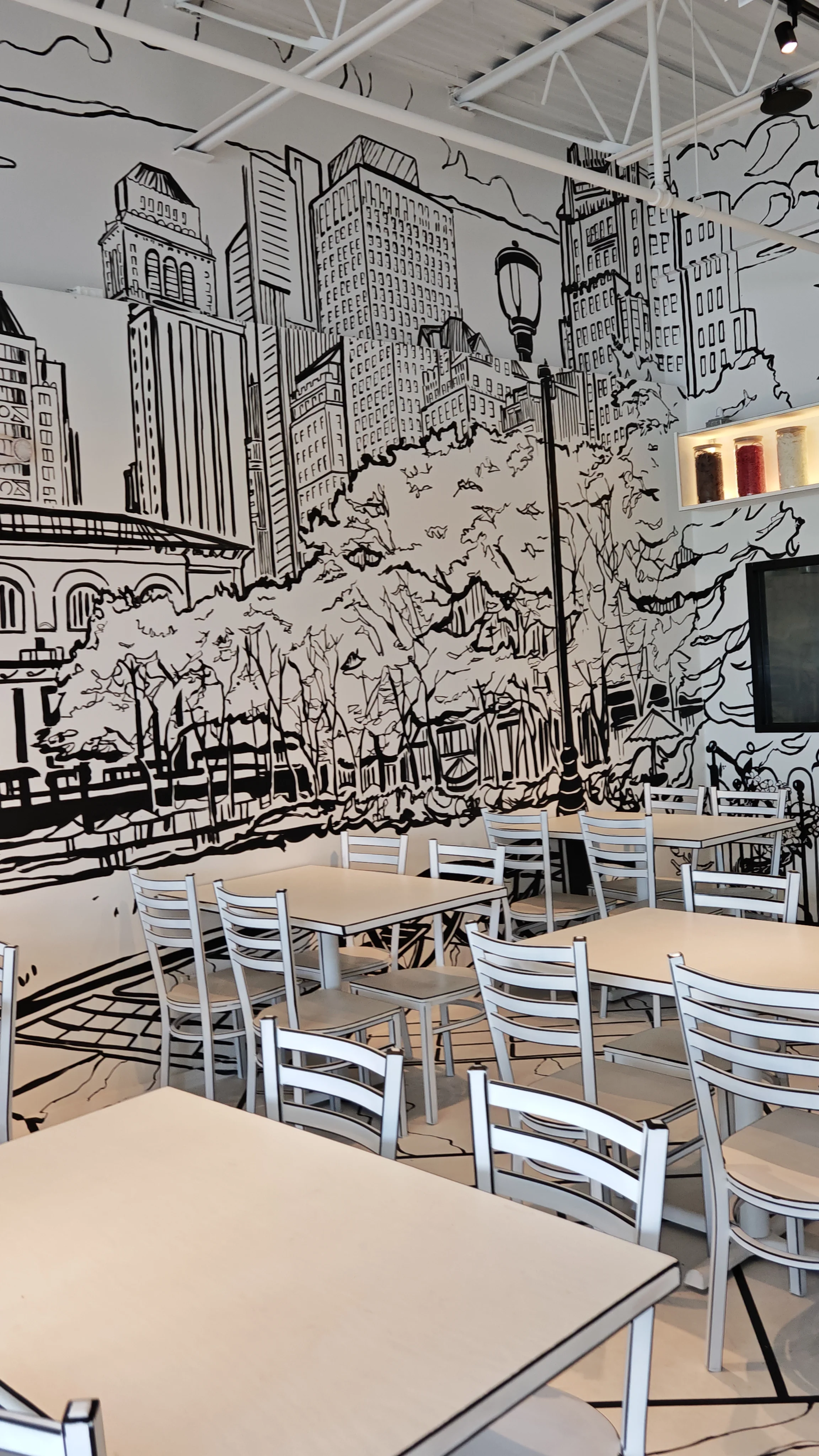 The unique 2-D cartoon-themed interior of Chopsticks Charm, where the walls, tables, and chairs are designed to look like a black and white drawing.
