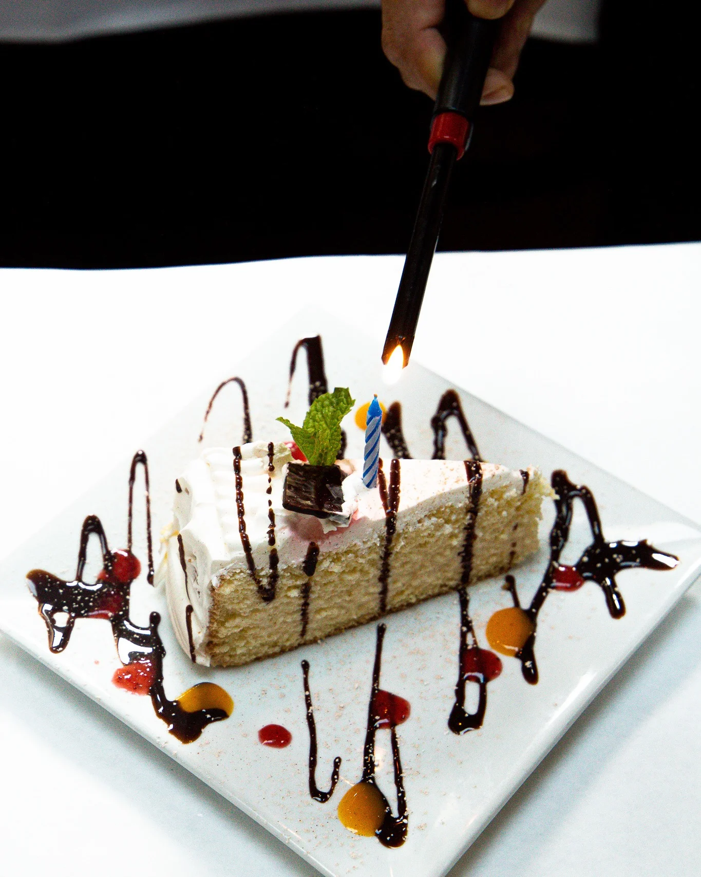 Birthday cake slice with candle and chocolate drizzle