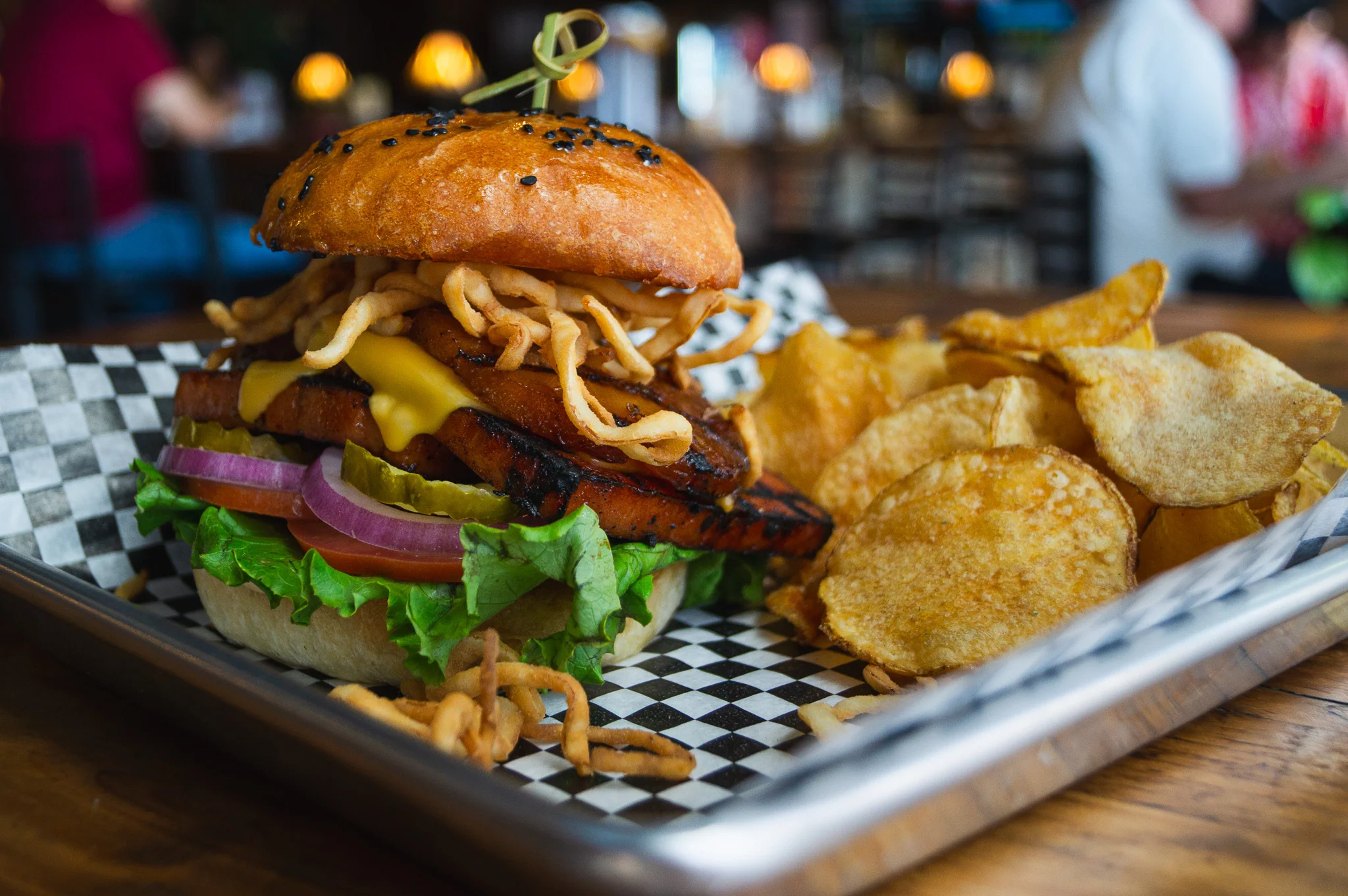 Grilled BBQ burger with crispy onions and potato chips