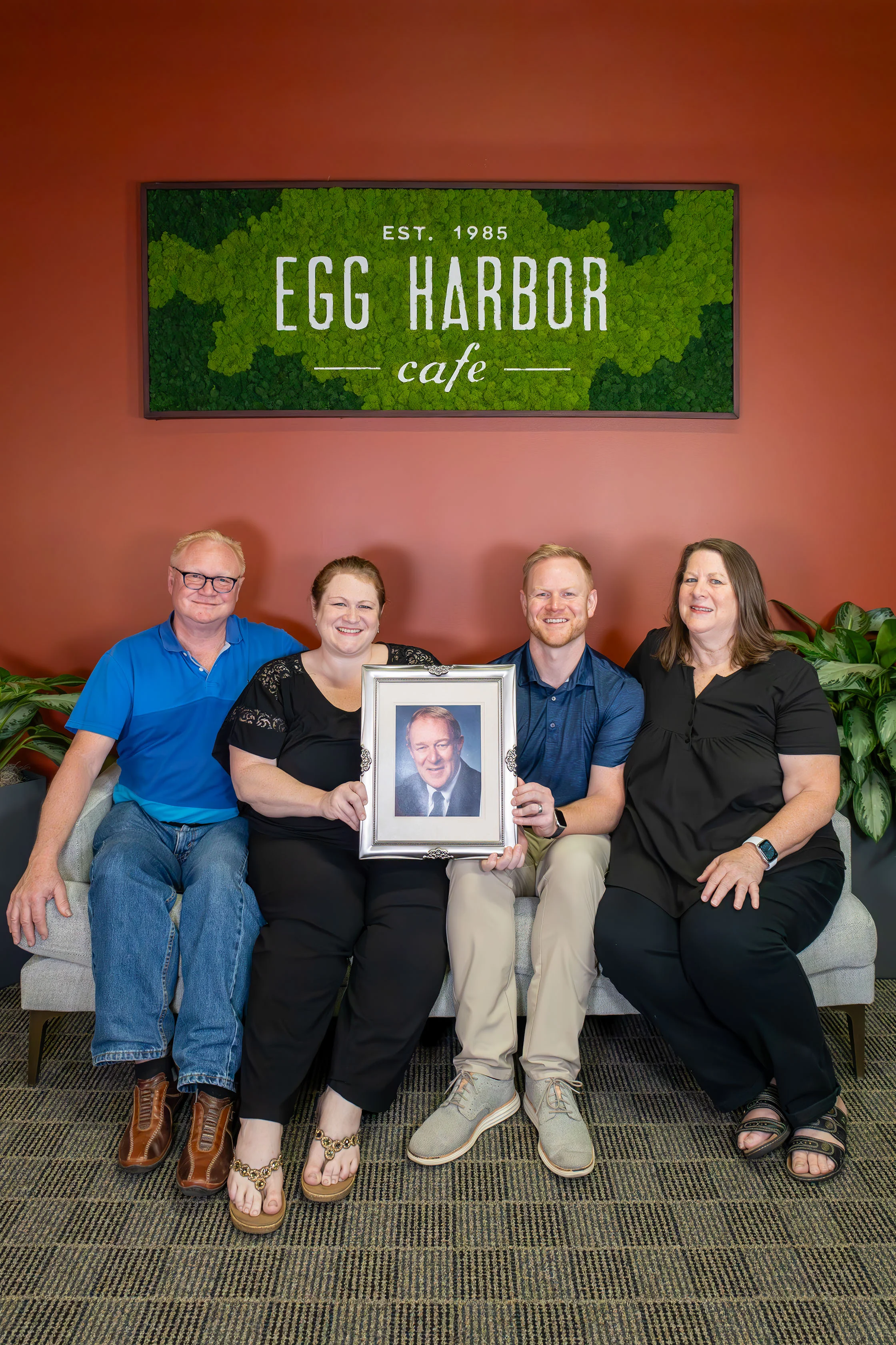 Family portrait at Egg Harbor Cafe with a framed photo