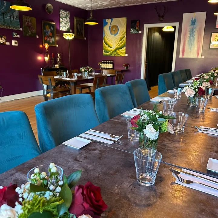 Cozy restaurant interior with purple walls and elegant table settings