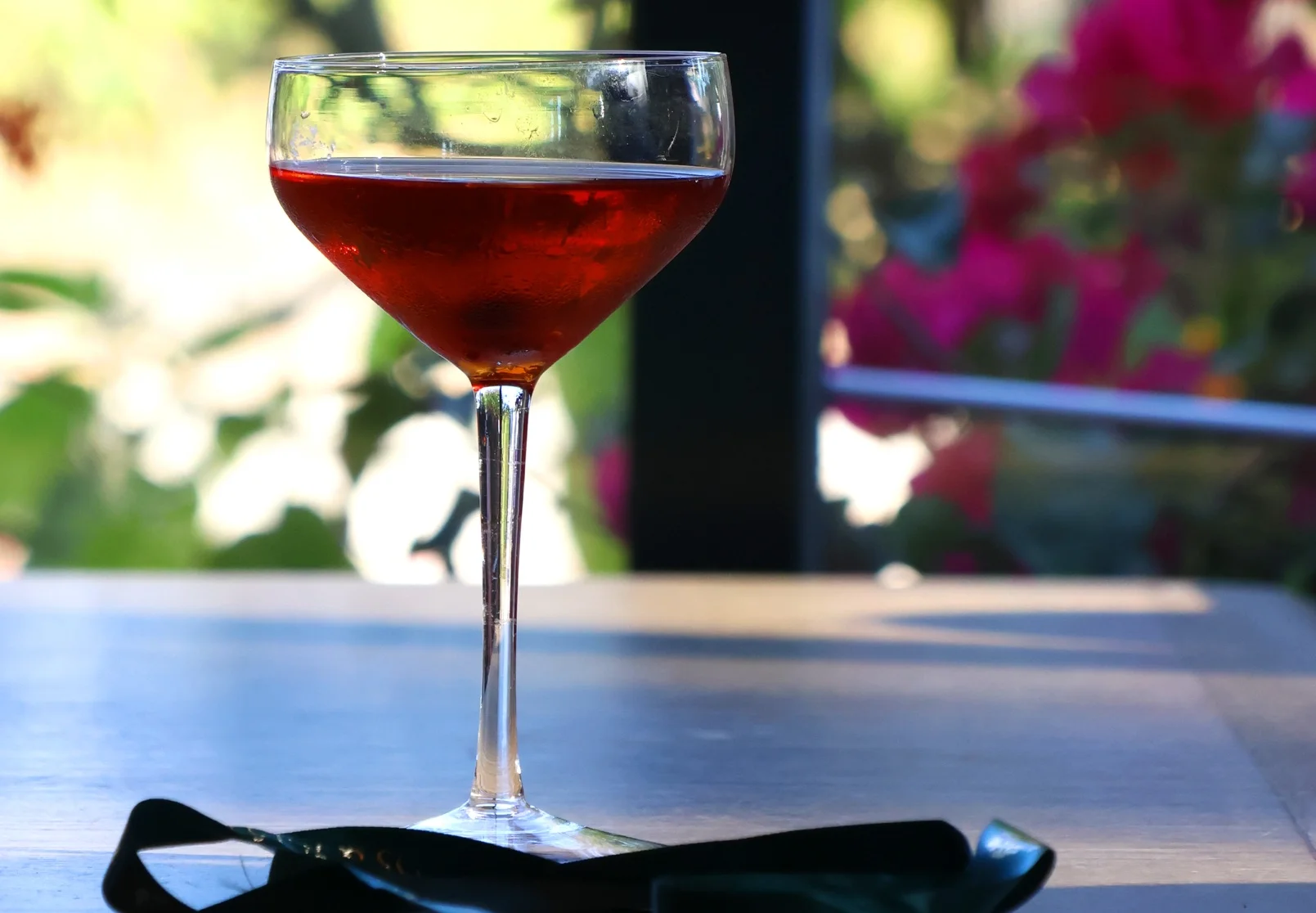 Elegant cocktail in a coupe glass on a wooden table