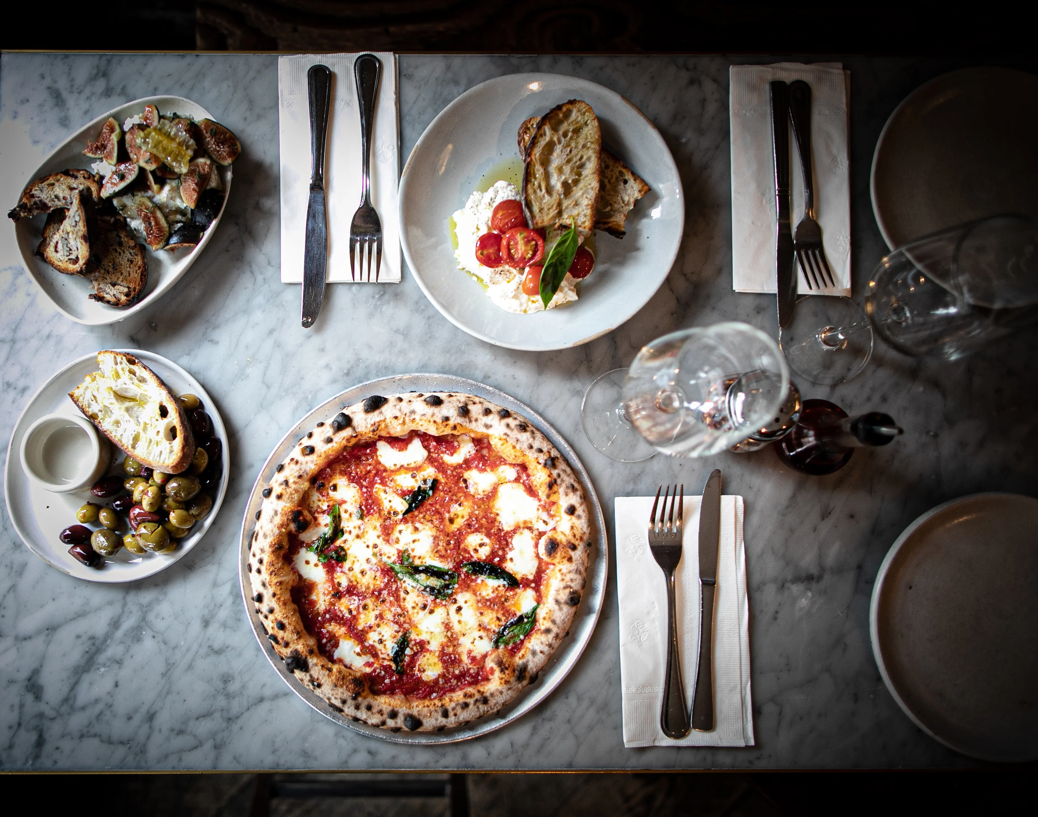 Margherita pizza with fresh basil on a marble table