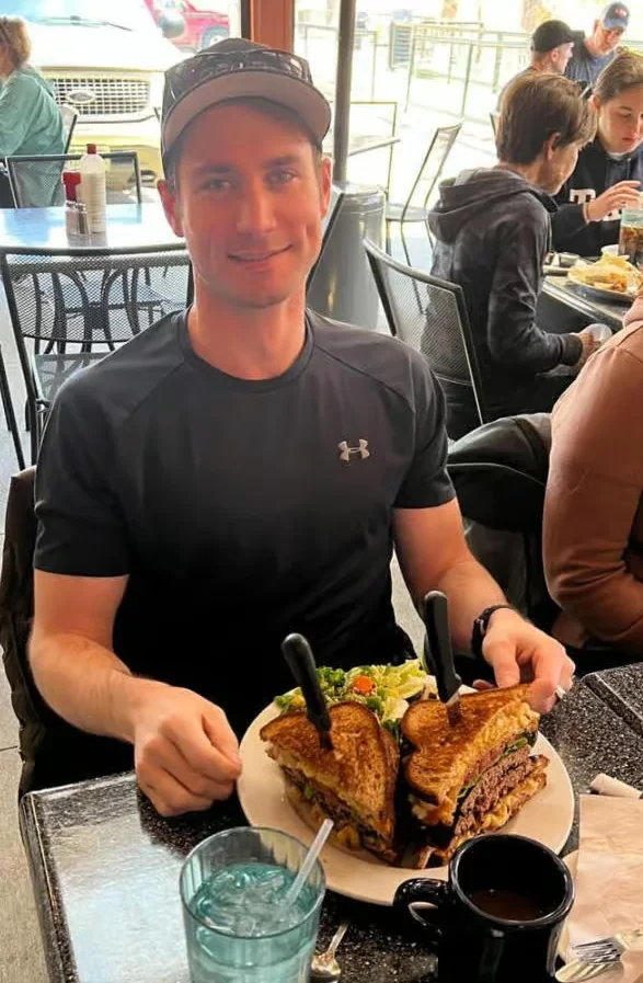 Giant grilled cheese sandwich with salad in a cozy restaurant setting