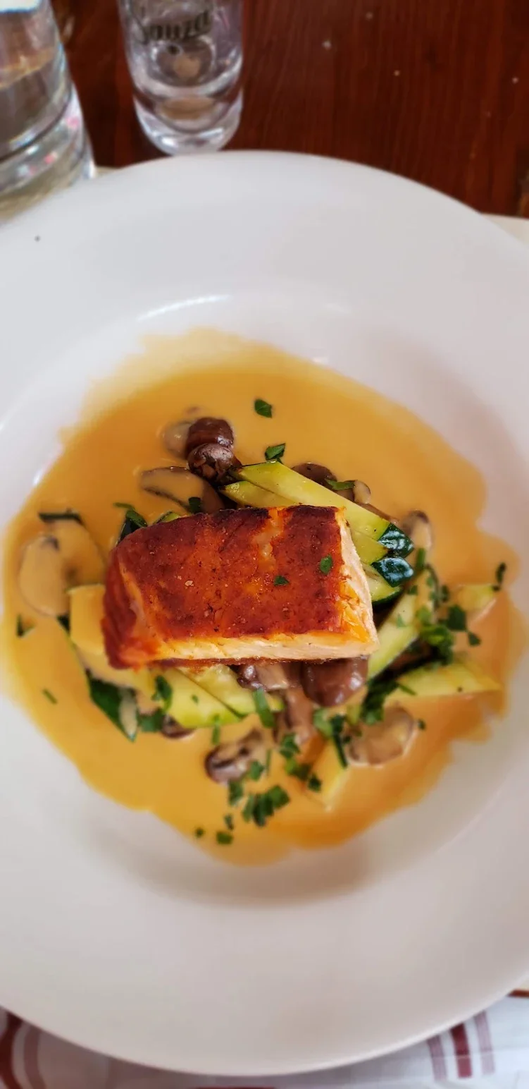 Pan-seared fish with creamy sauce and vegetables, elegantly plated