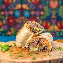 Cut-open Mexican burrito served on a wooden board