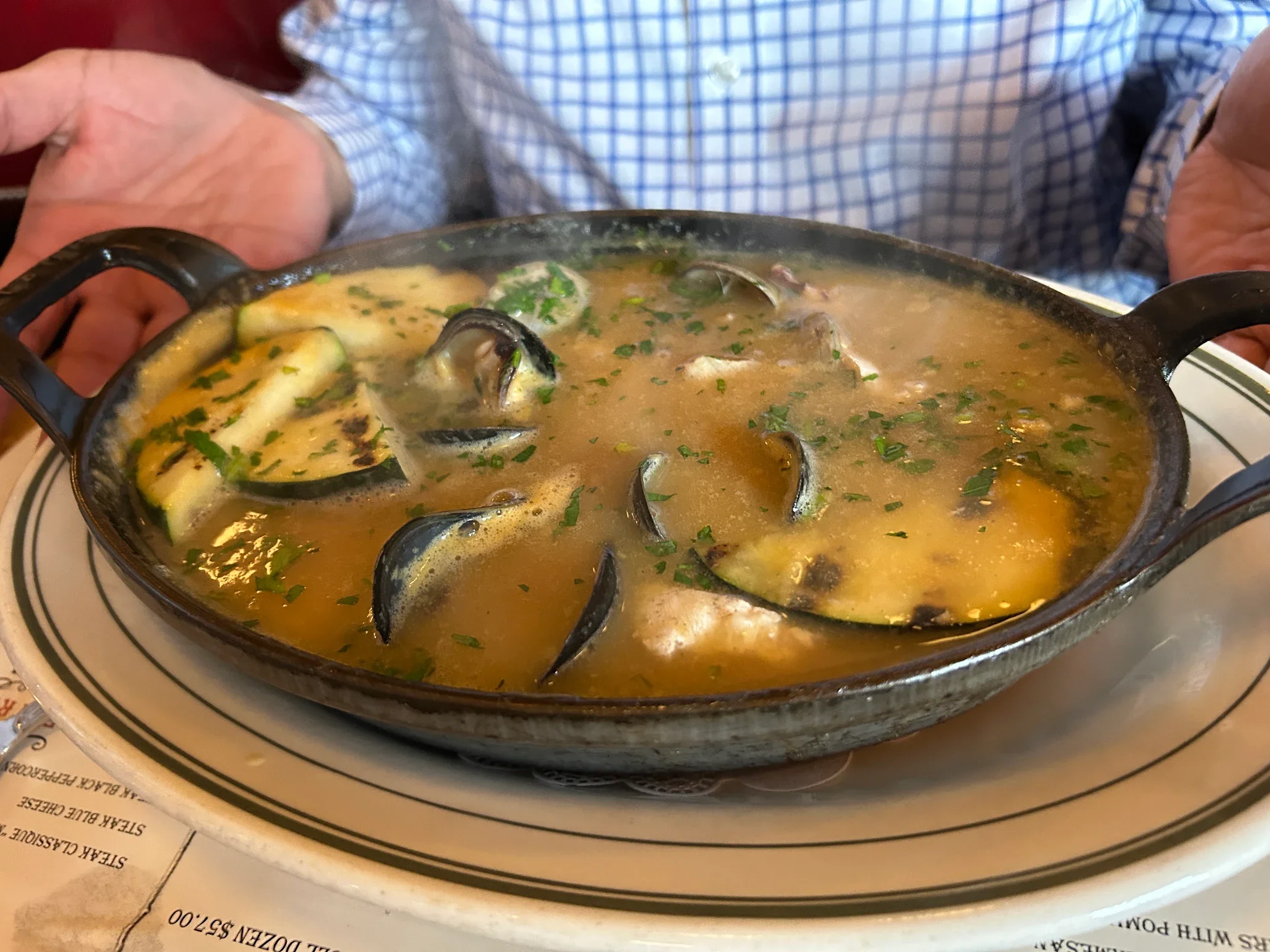 Steaming bowl of Italian cioppino with seafood and herbs