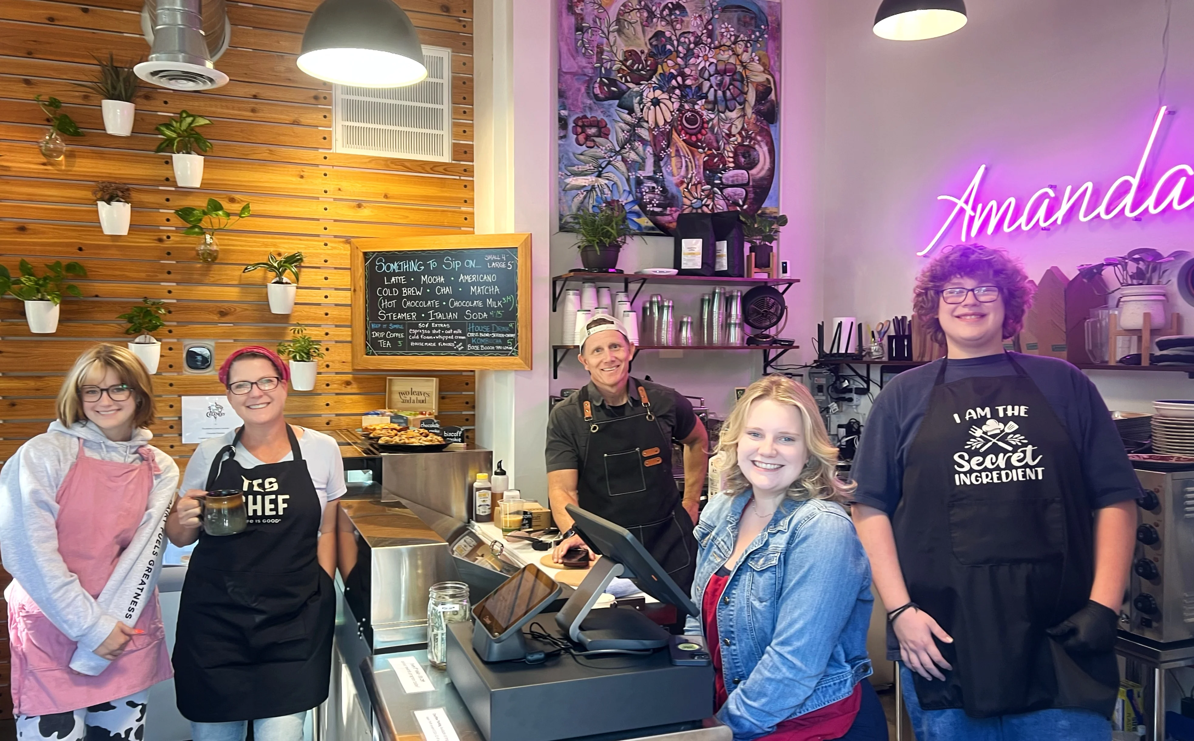 Friendly café staff behind the counter in a cozy setting