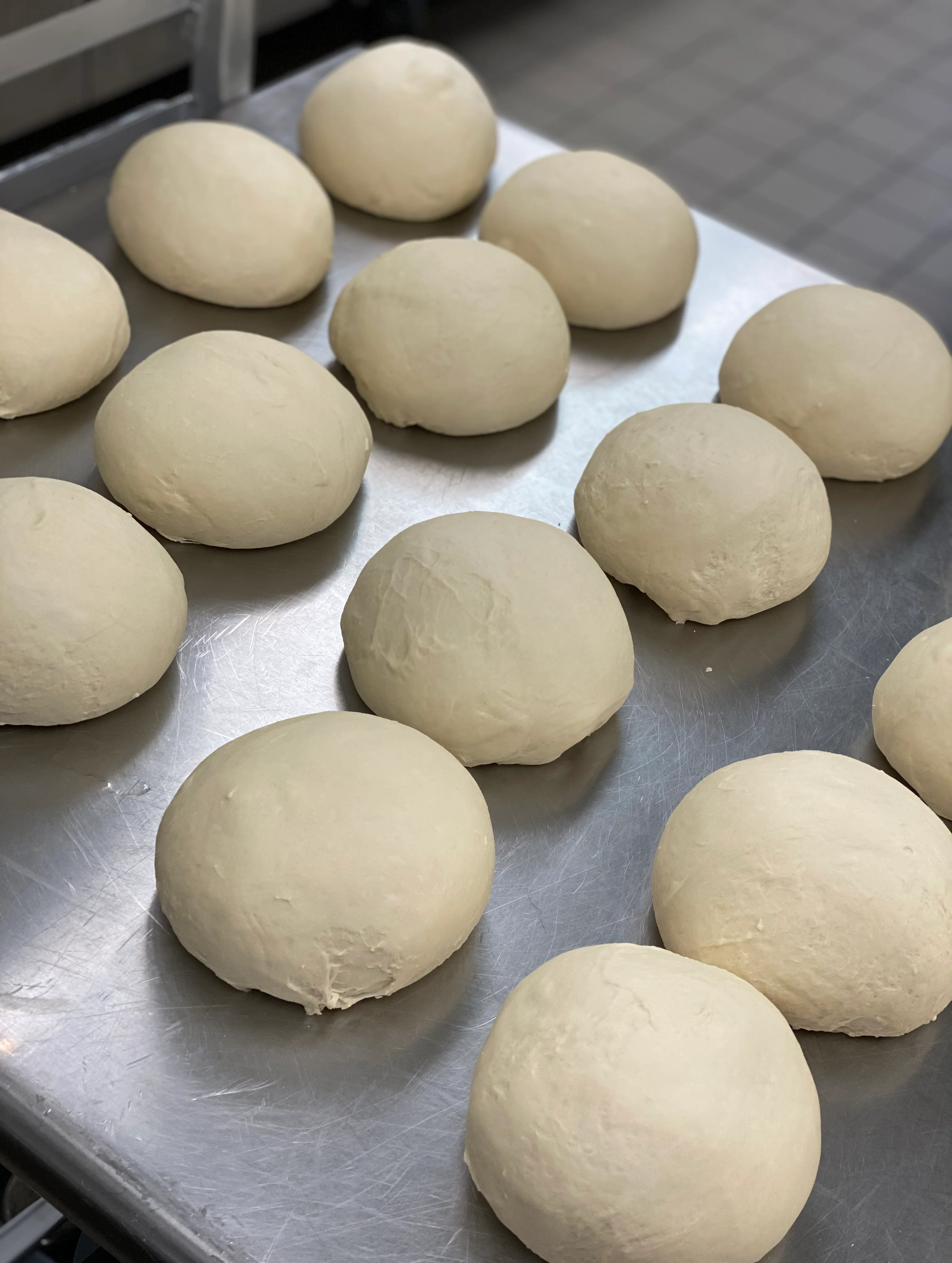Freshly prepared pizza dough balls ready for baking