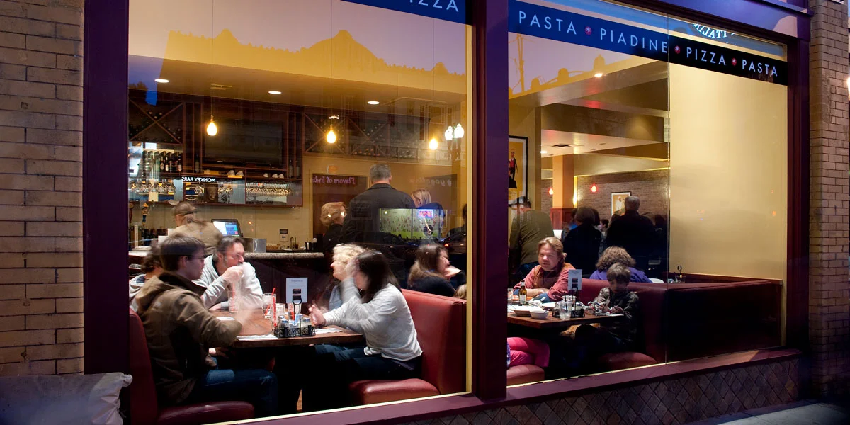 Front of restaurant featuring guests dining in and smiling