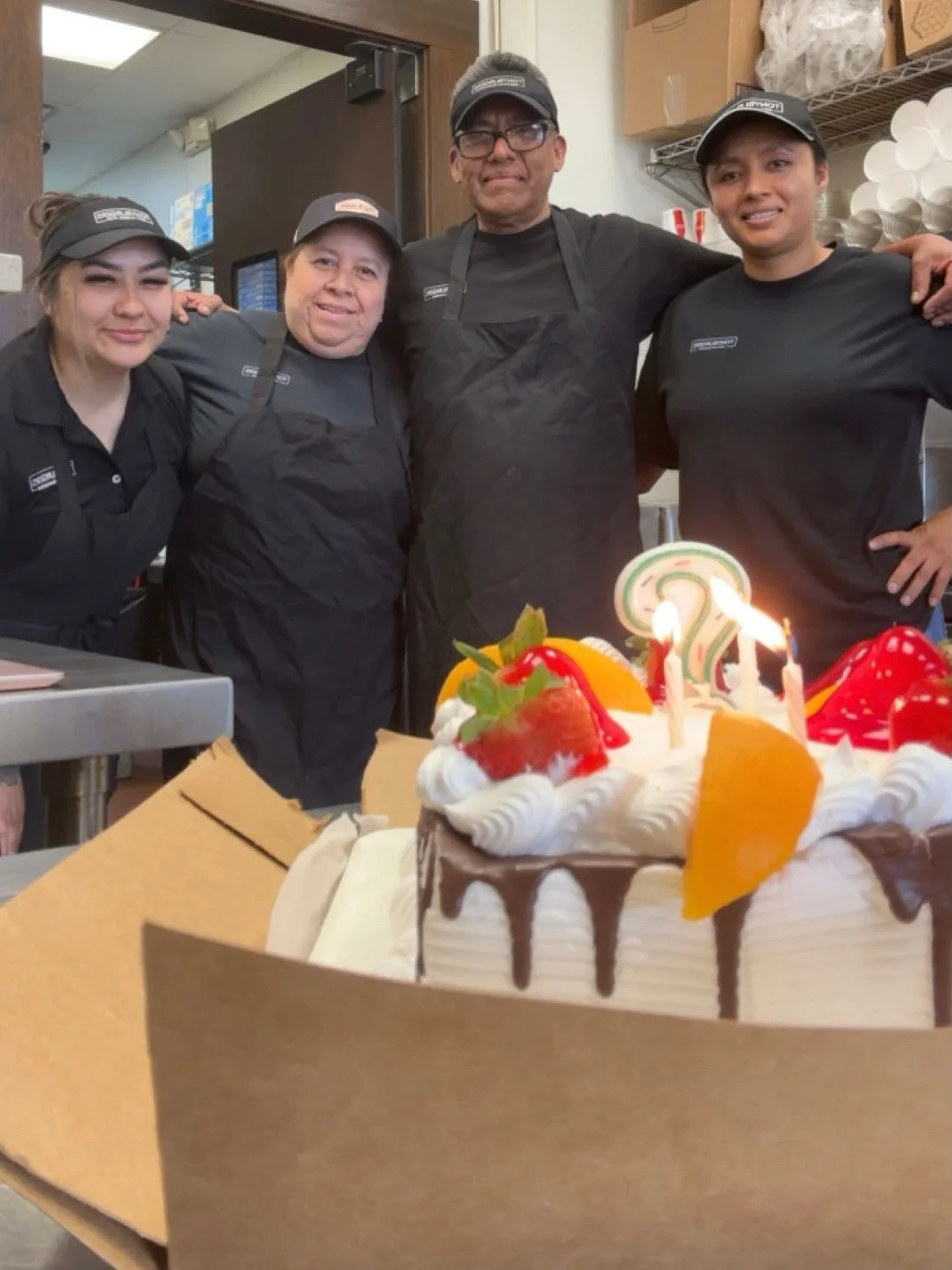 Celebratory cake with candles in a restaurant kitchen setting