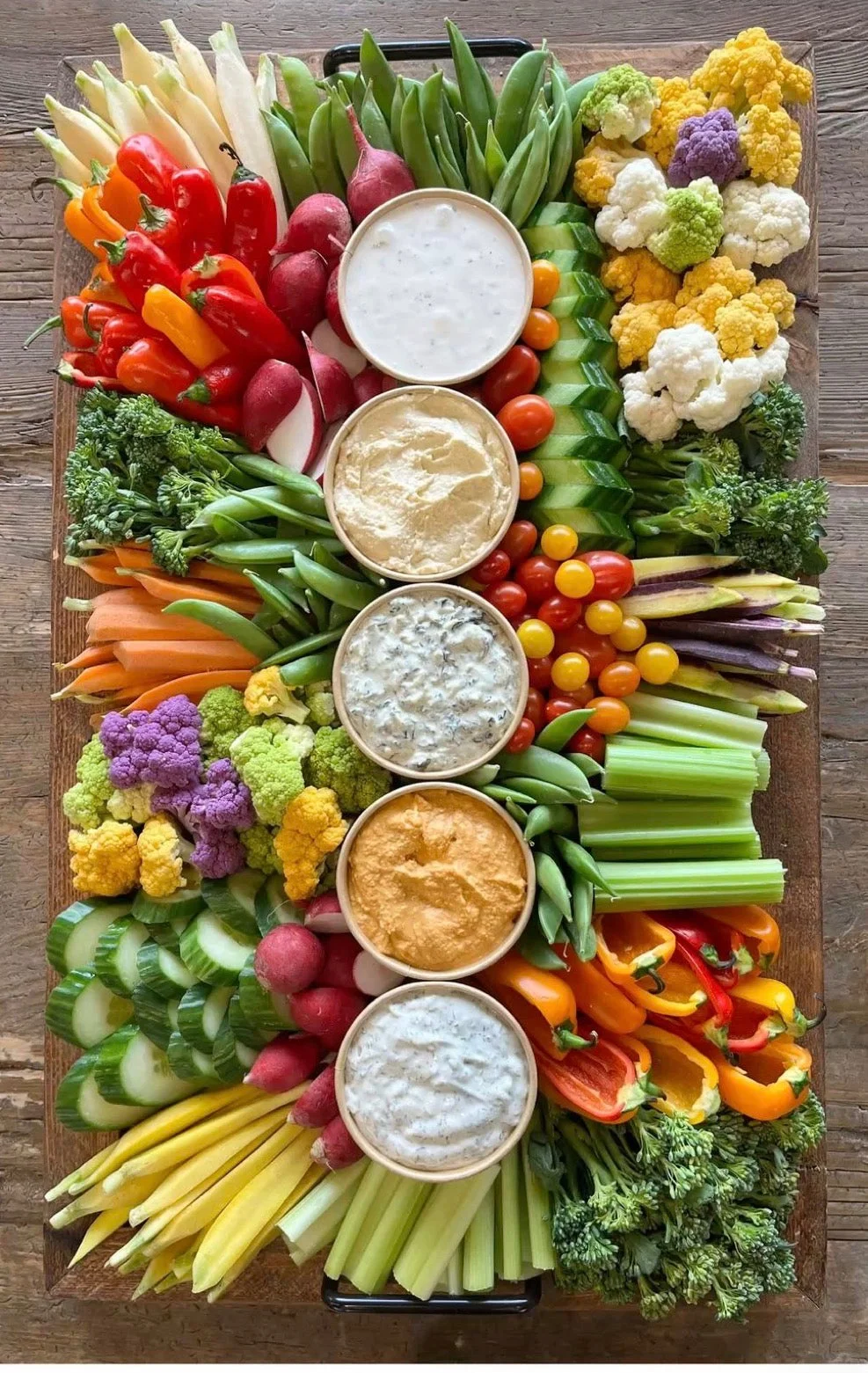 A beautifully arranged table for creating parfaits with a variety of toppings including fruits, nuts, and yogurt. A chalkboard sign invites guests to 'Build Your Own Parfait'.