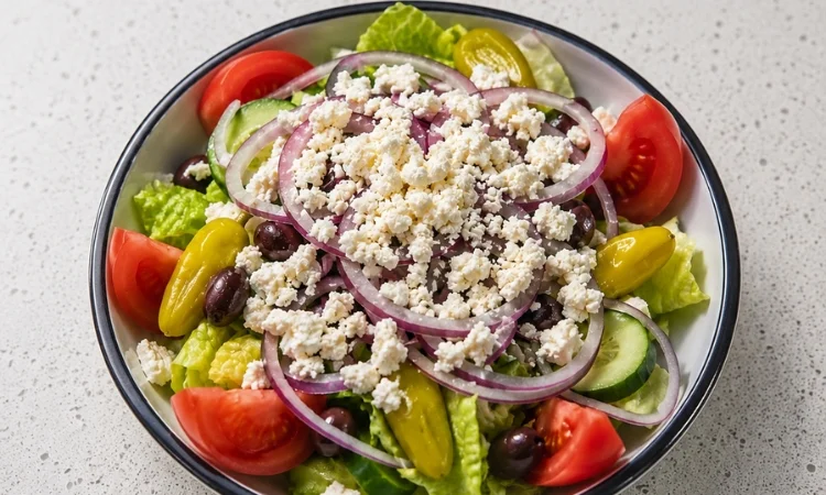 Cucina salad being topped with vinegar and oil