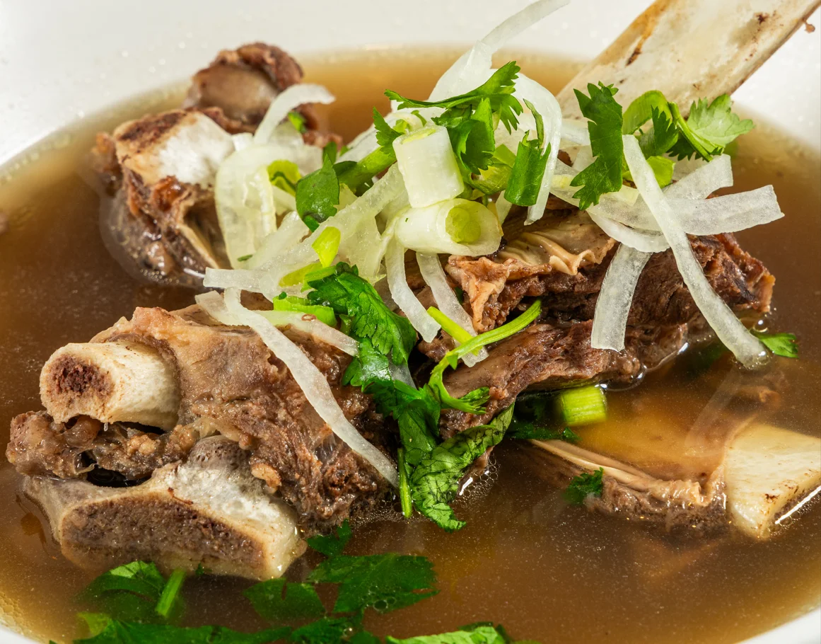 Bowl of Vietnamese pho with beef and fresh herbs
