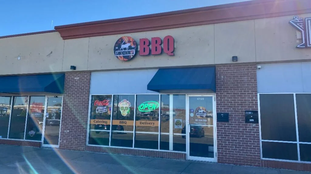 Exterior view of a BBQ restaurant with signage and open hours