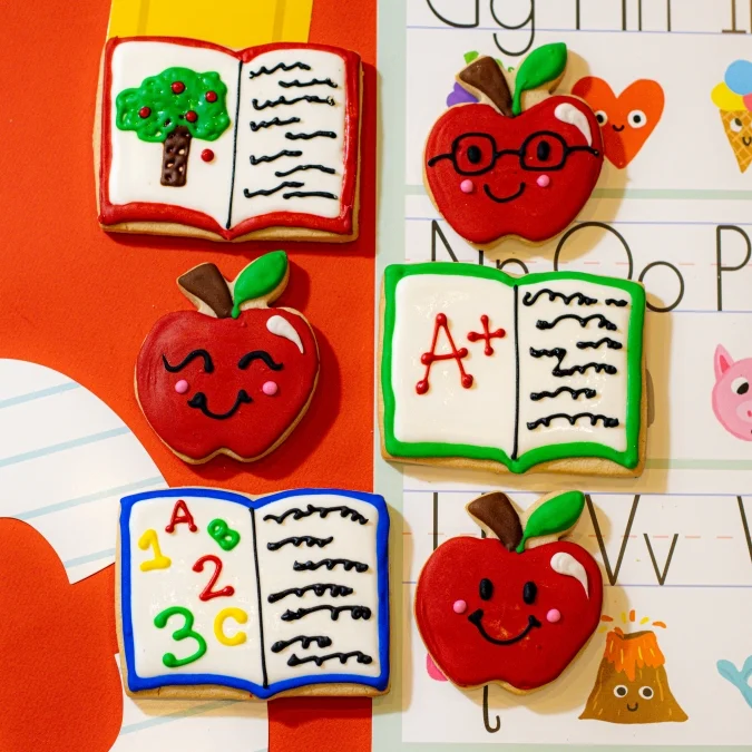Colorful decorated cookies shaped like apples and books