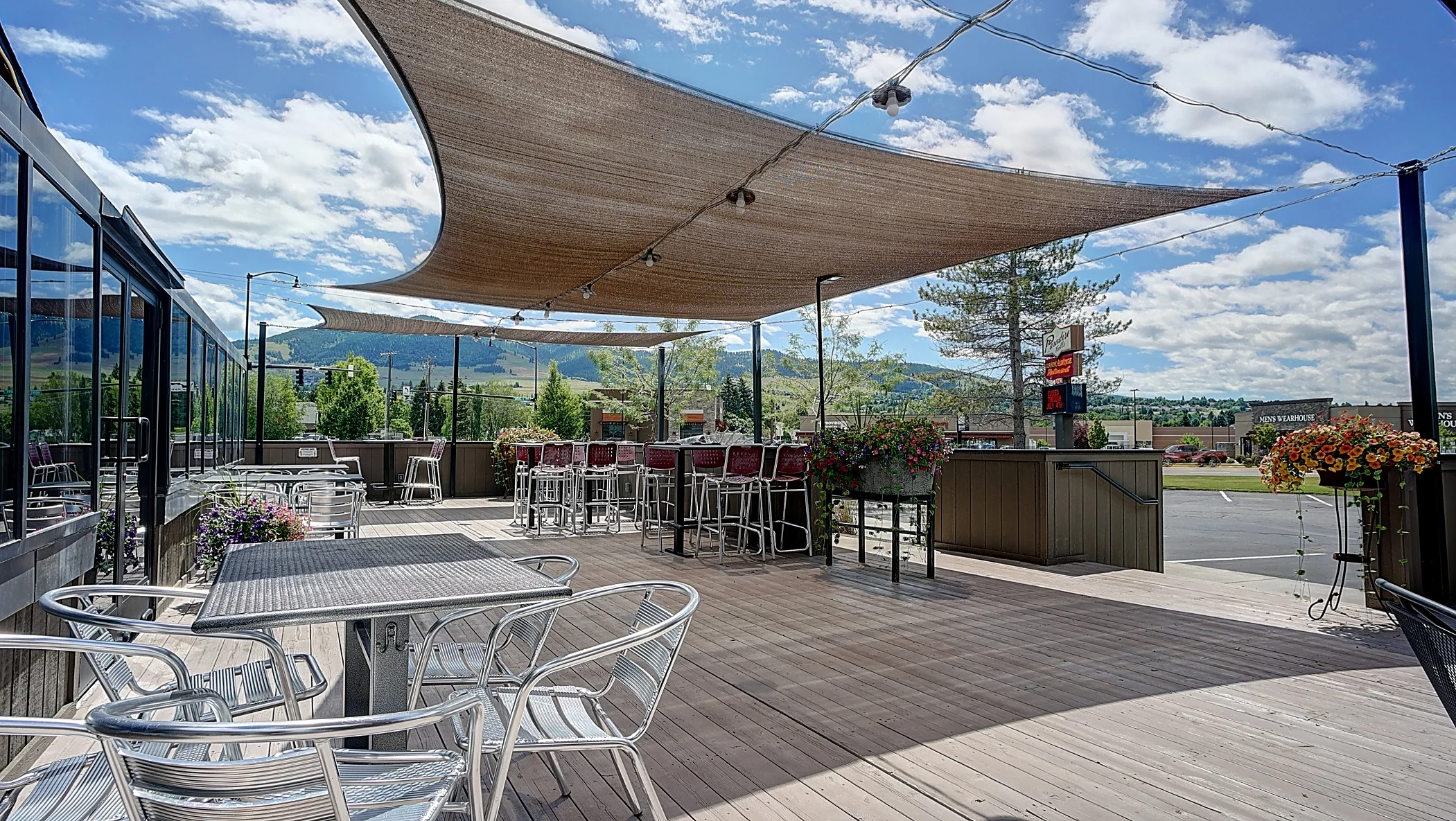 Outdoor dining area with shaded seating and mountain views