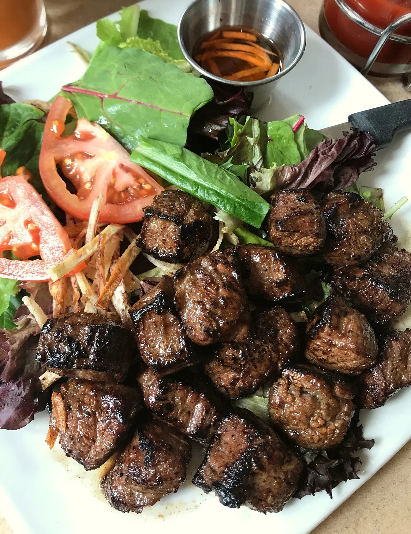 Grilled beef skewers served with fresh salad
