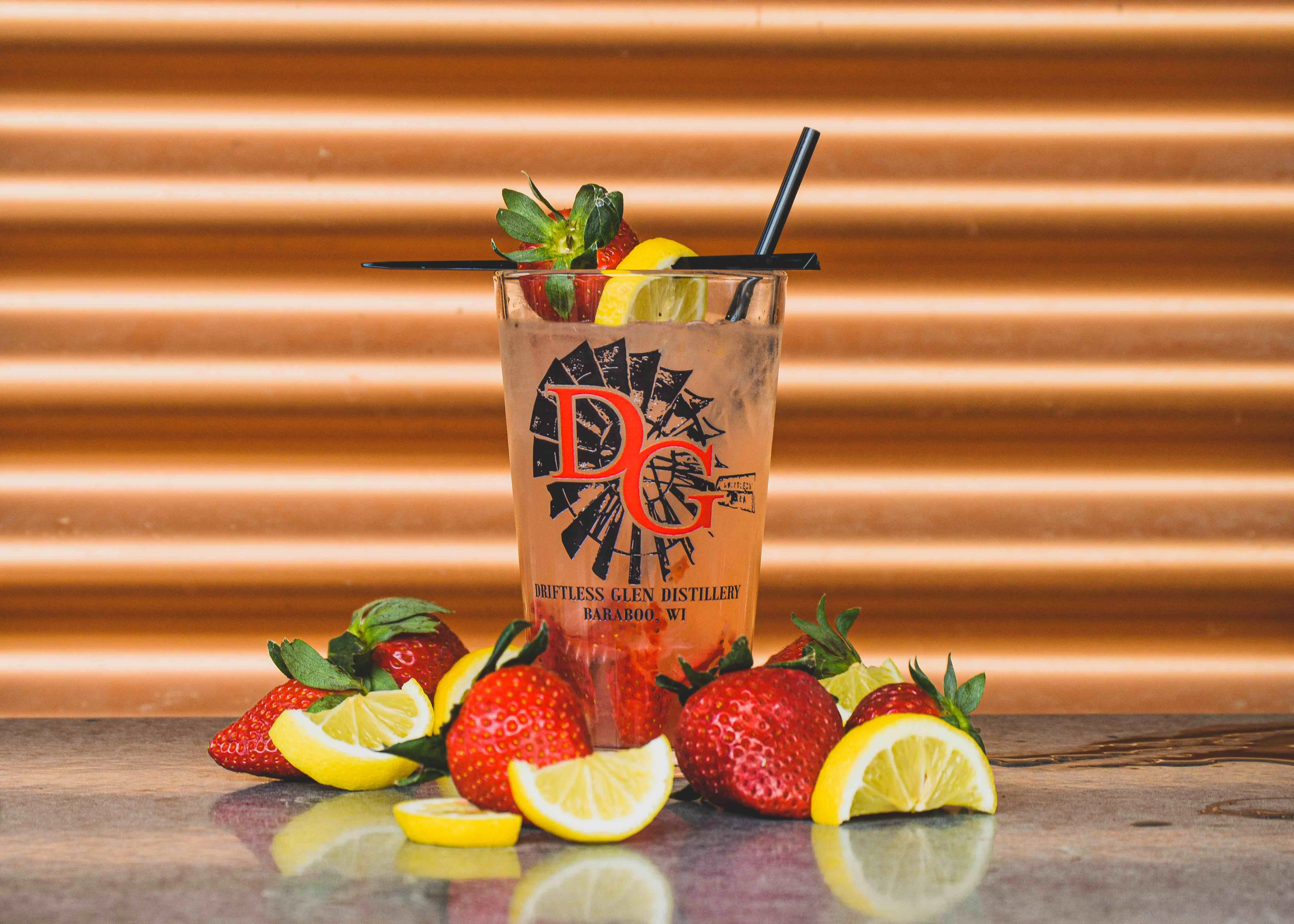 Strawberry Lemonade cocktail with a bunch of lemon slices and strawberry slices scattered around it