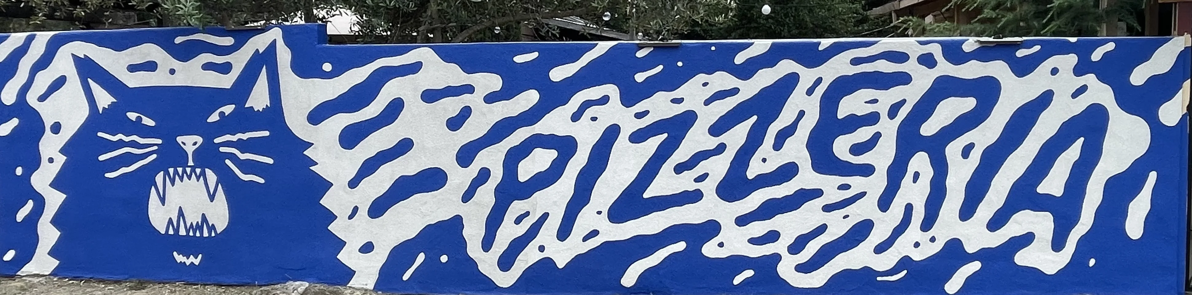 Colorful mural featuring a fierce cat design on a blue background