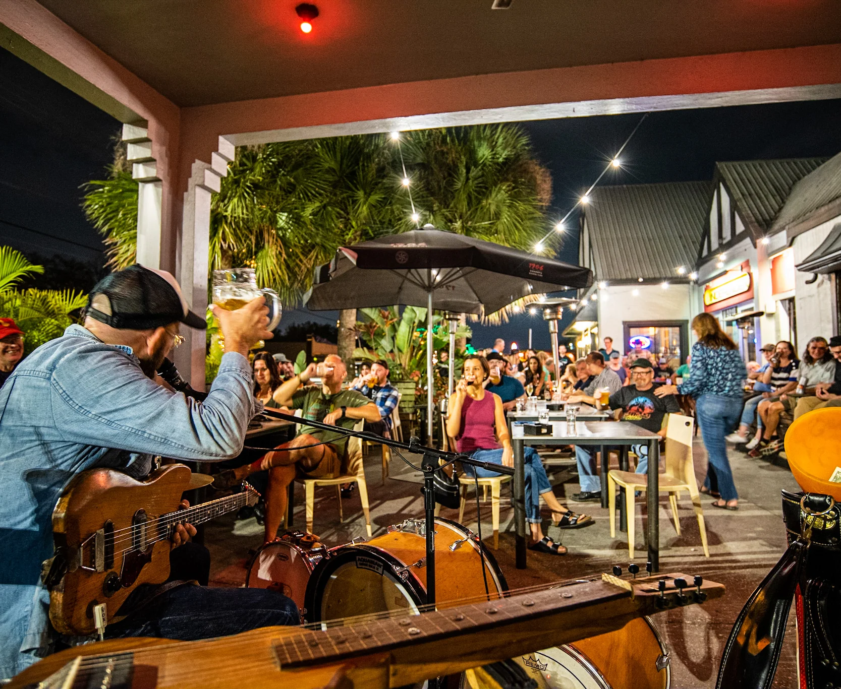 Live music performance at a vibrant outdoor restaurant with a lively crowd.