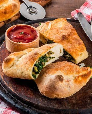 Savory calzones filled with spinach and cheese served with marinara sauce