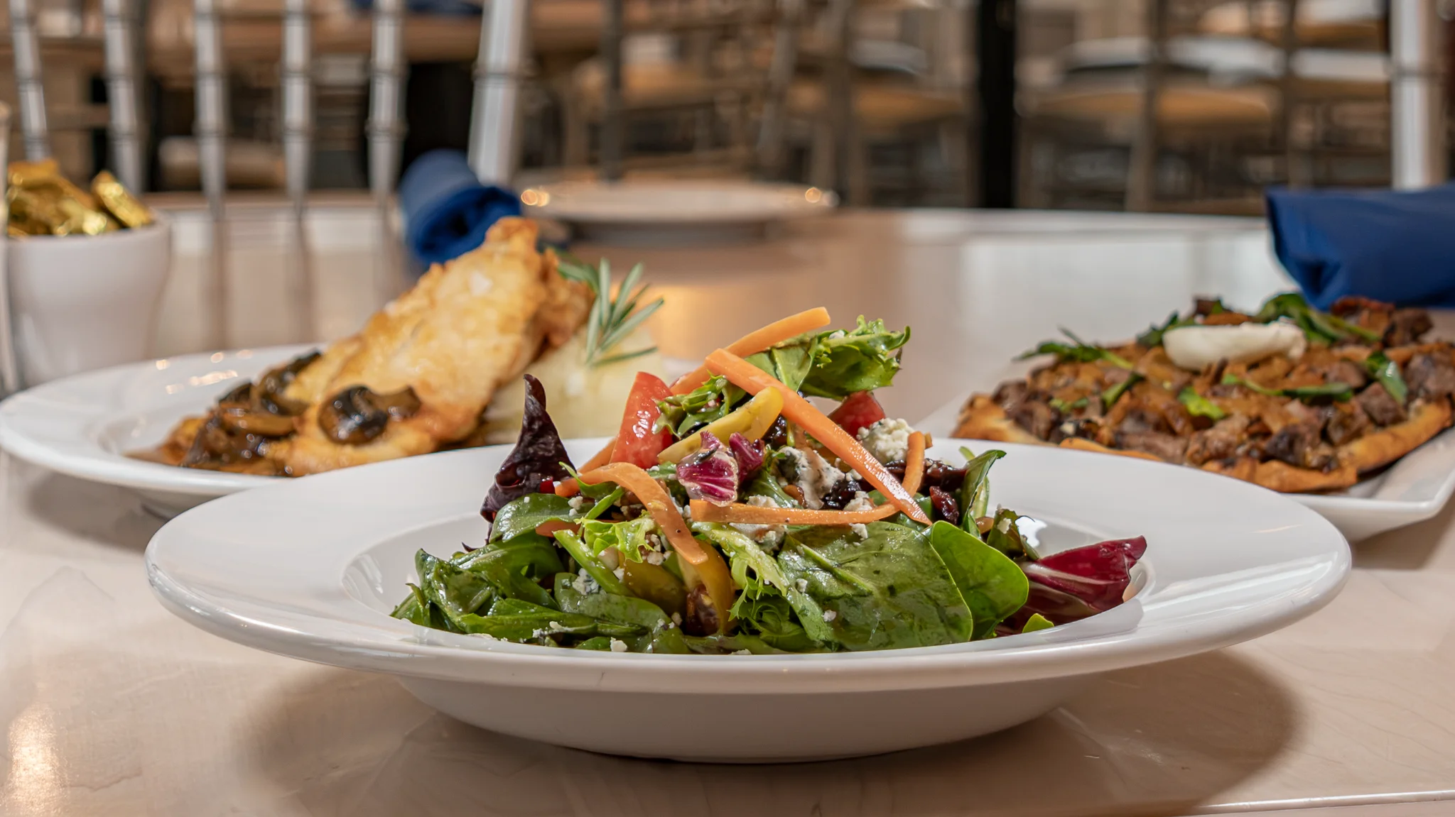 A classic Caesar salad with romaine lettuce, croutons, and sprinkled with cheese. The ingredients are elegantly arranged on a white plate.