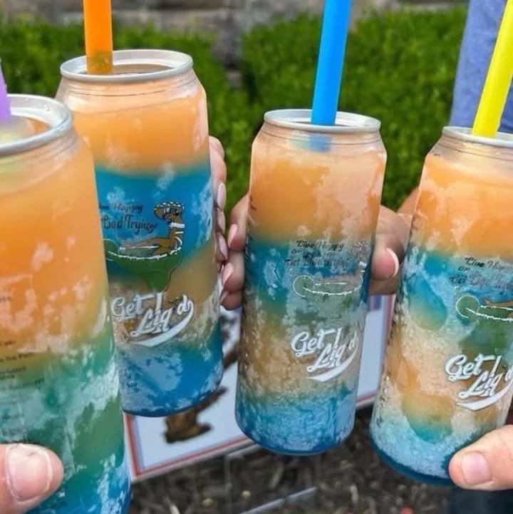 Colorful frozen cocktails in cans with straws