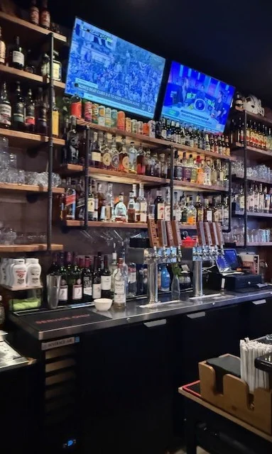 A vibrant bar backdrop featuring colorful bottles and a stylish design.