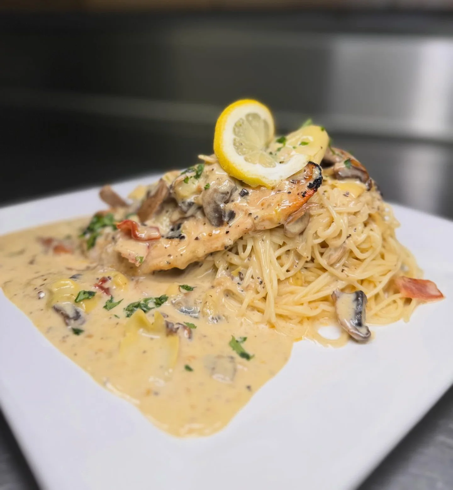 Creamy chicken fettuccine alfredo with lemon garnish