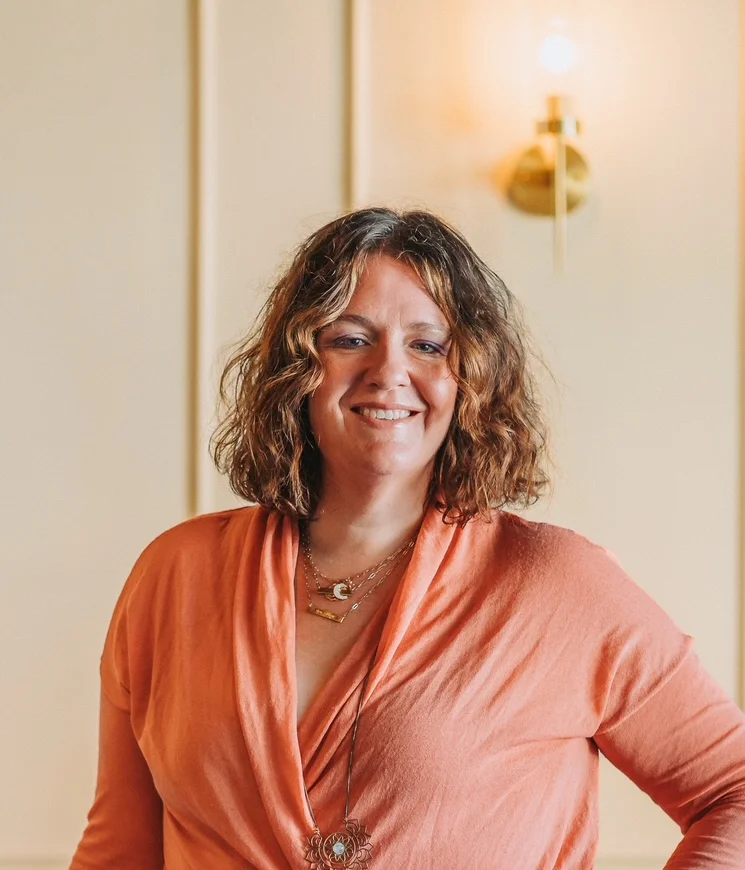 Smiling woman in a restaurant setting with elegant decor