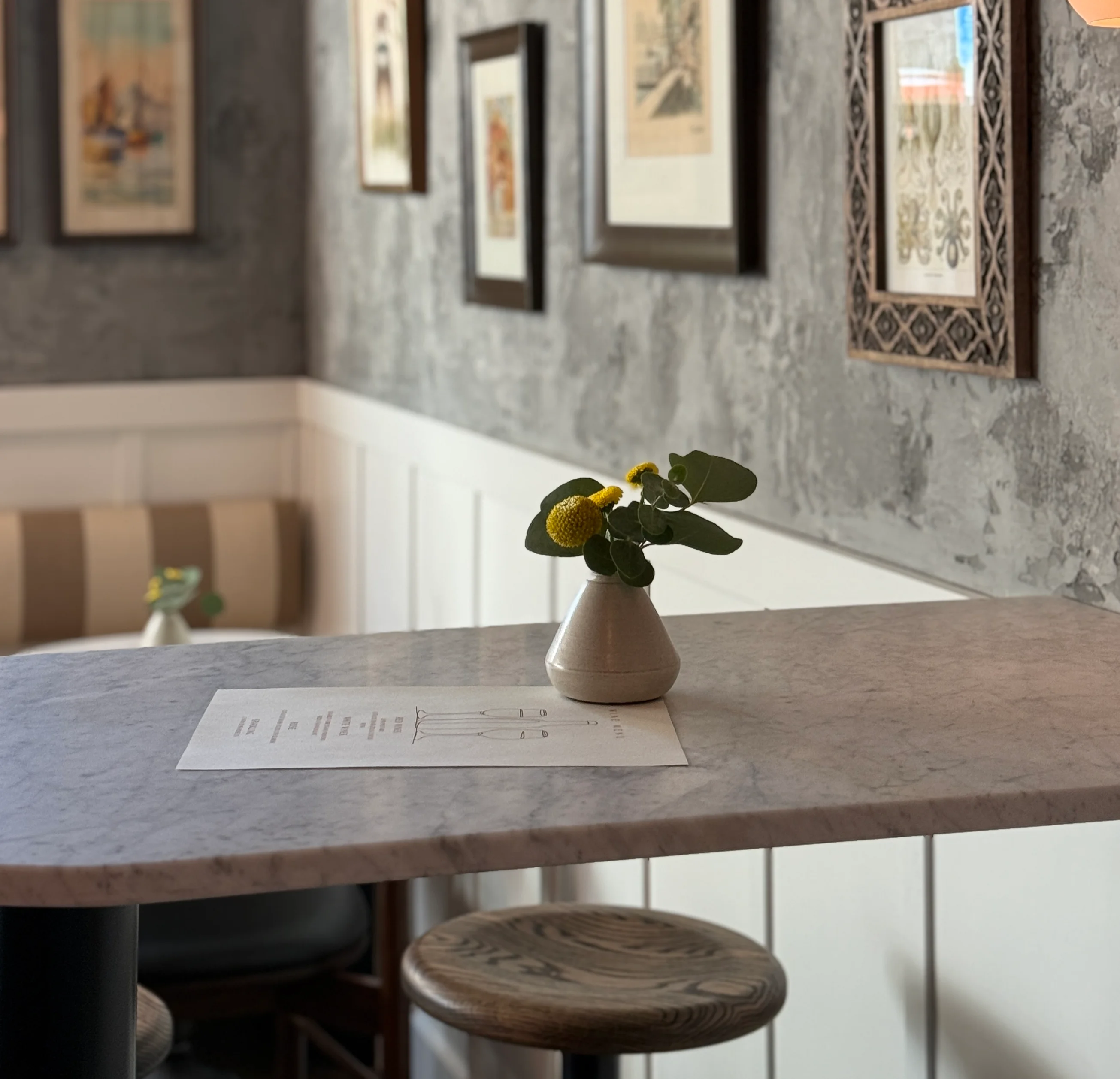 Cozy restaurant interior with framed art and a marble table
