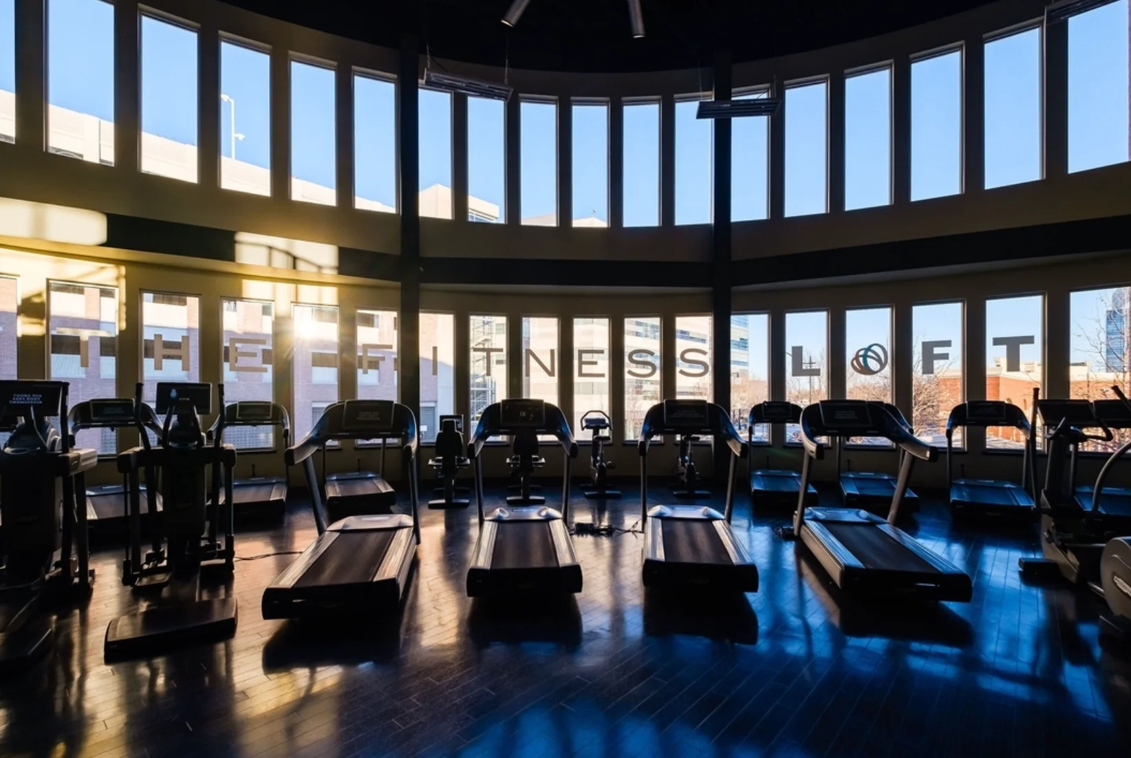Modern fitness center with treadmills and large windows