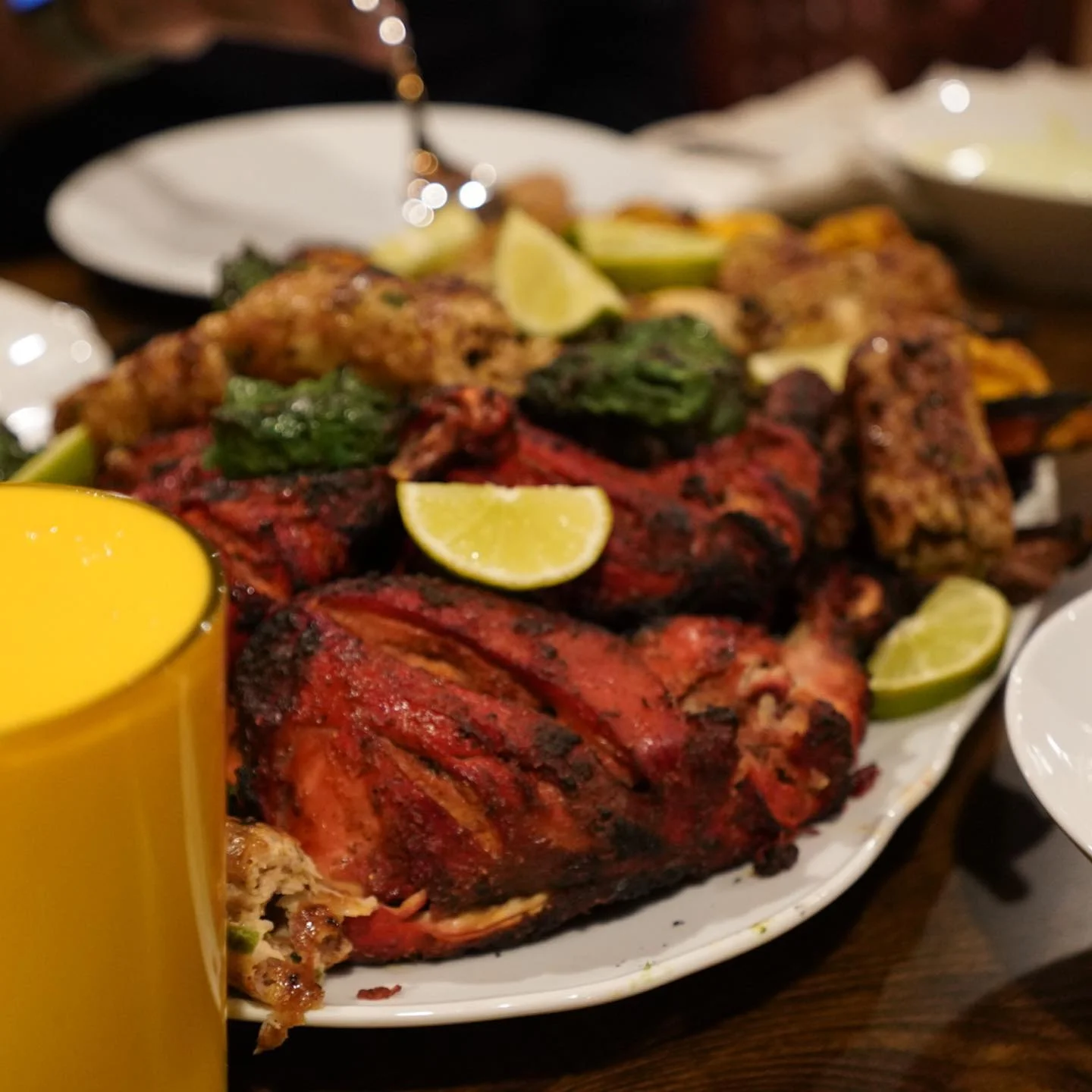 An array of vibrant Indian dishes including rice, curries, samosas, and flatbreads, served with various garnishes and sauces.
