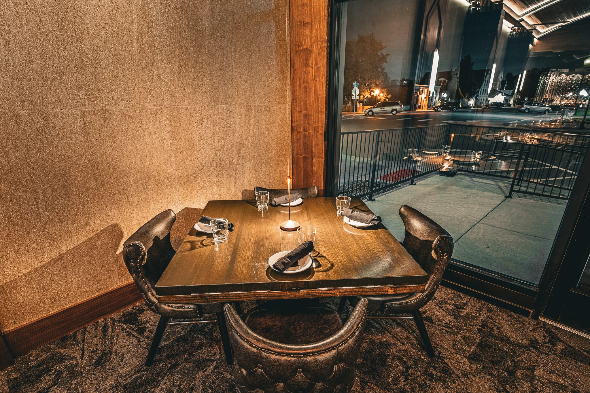 Elegant restaurant dining area with candlelit table and city street view