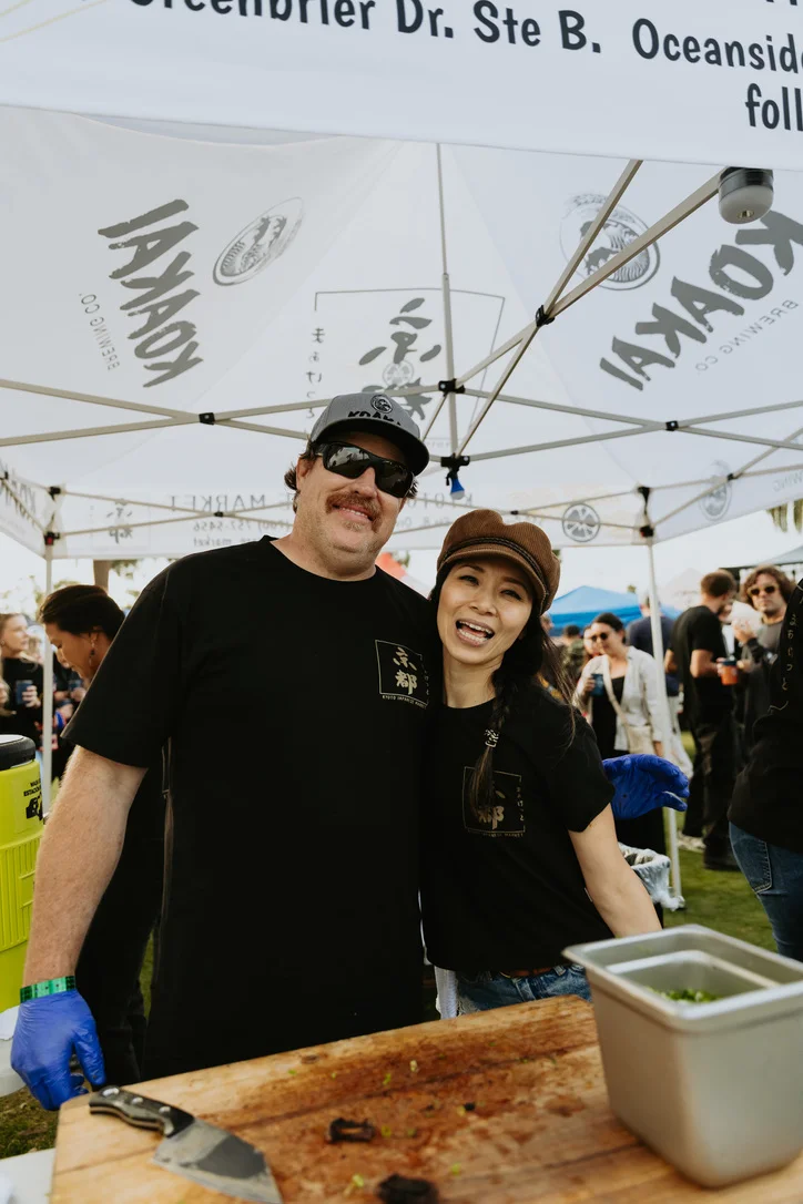 Cheerful vendors at a food festival booth