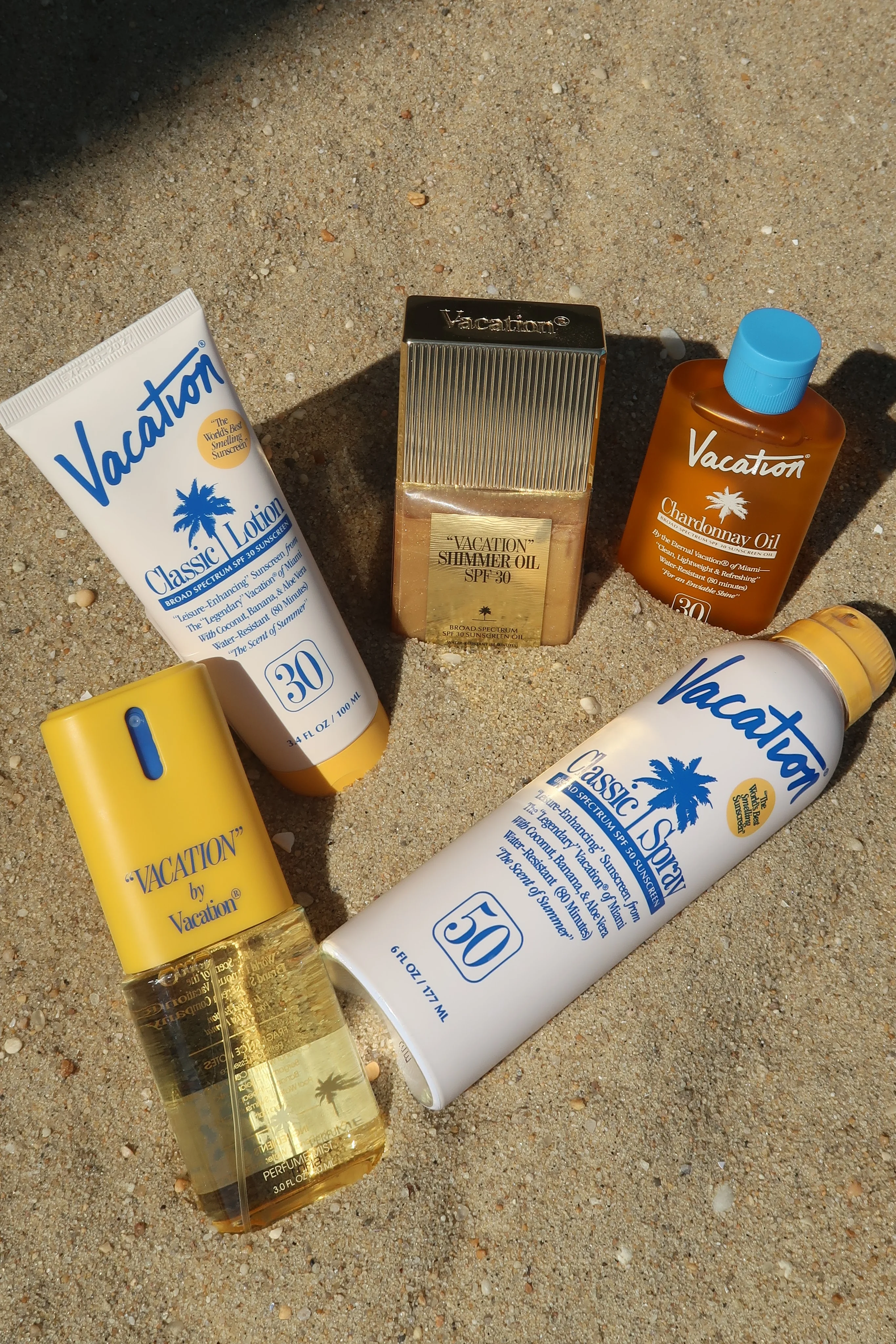 Assorted sun care products on sandy beach