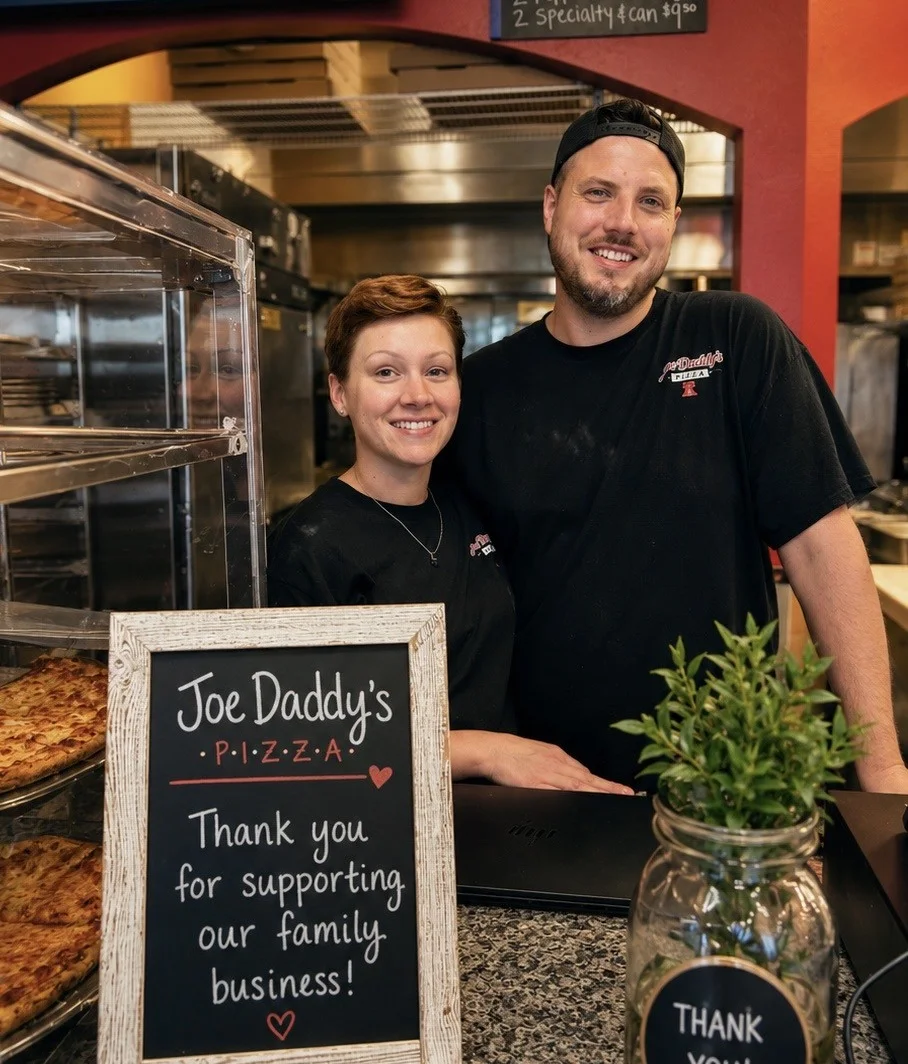 Friendly staff at Joe Daddy's Pizza with a thank you sign