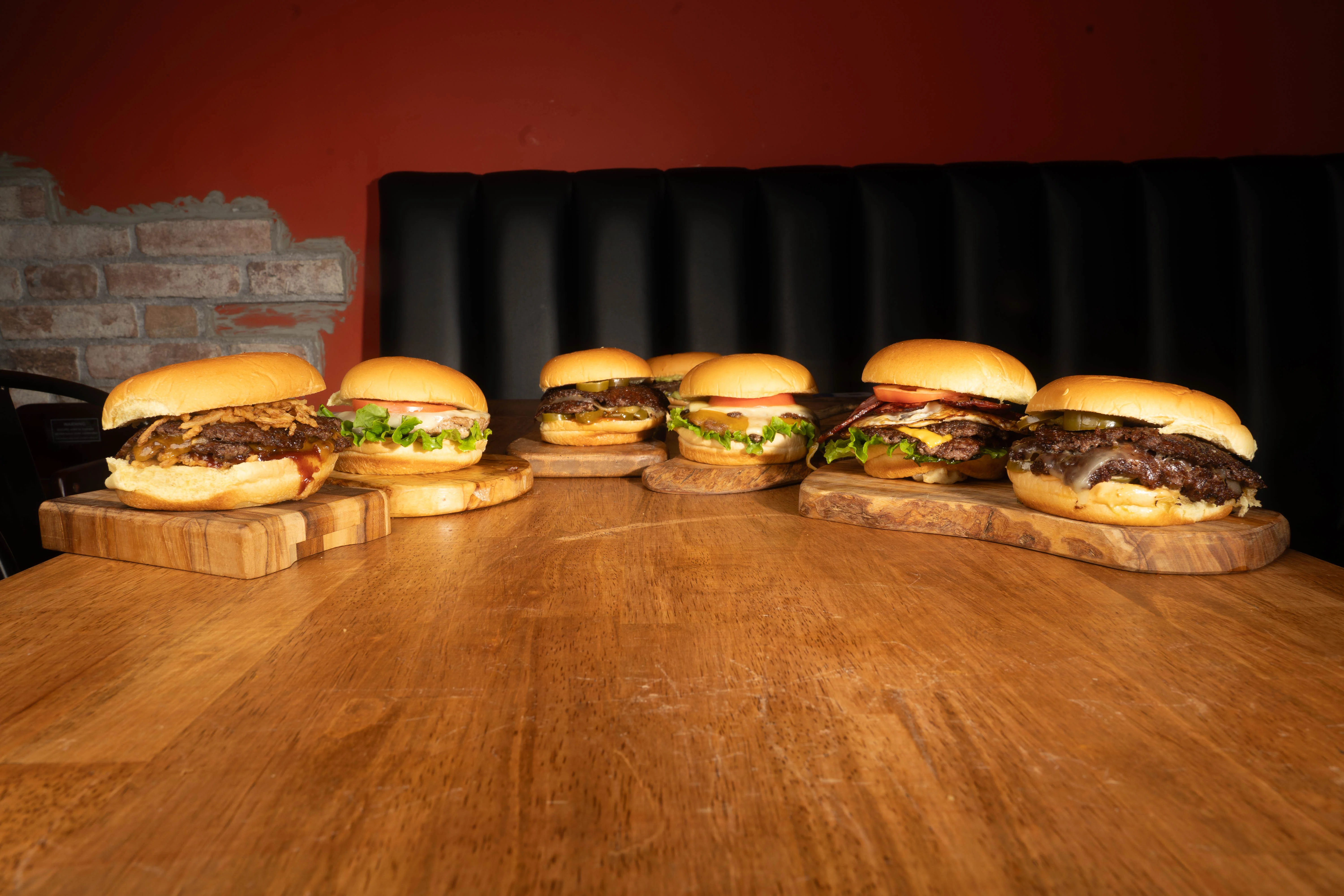 Gourmet burgers on wooden boards in a cozy restaurant setting
