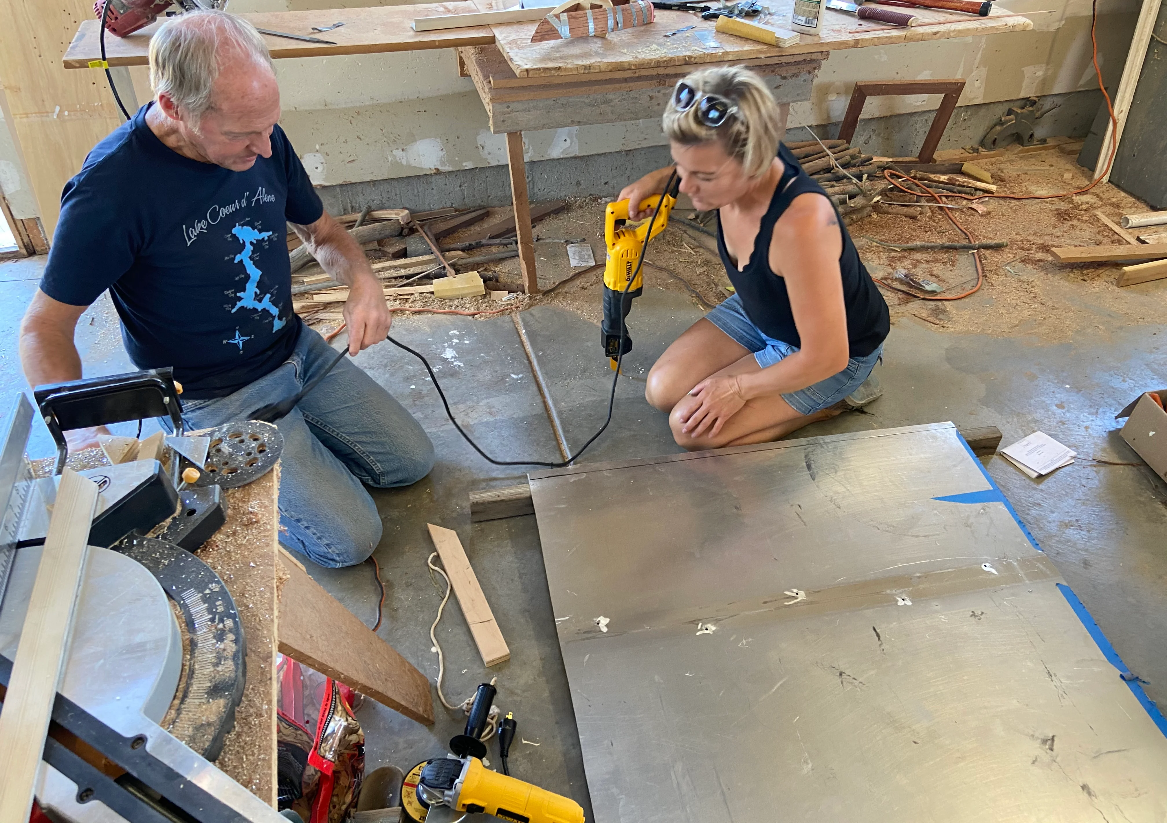 Two people working on a metal project in a workshop