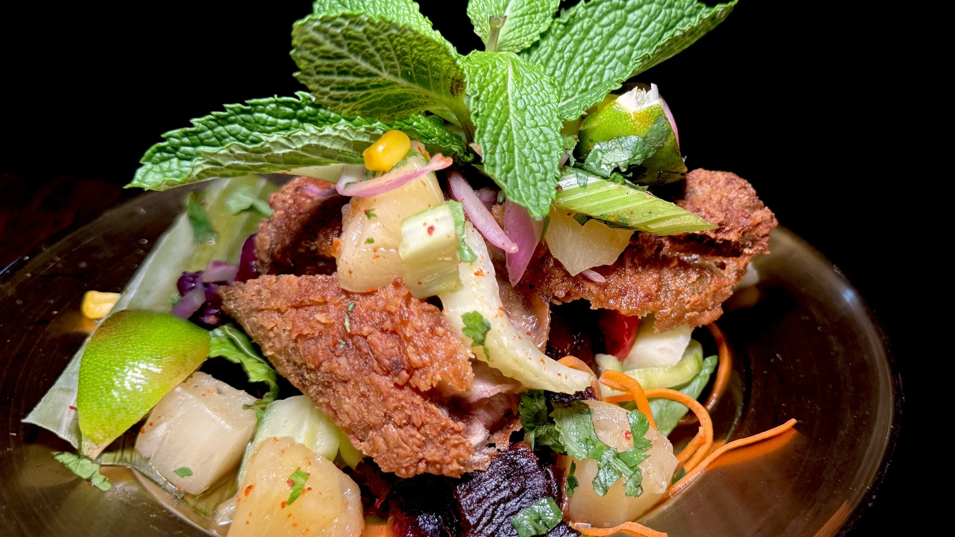 Crispy fried chicken salad with fresh herbs and vibrant vegetables