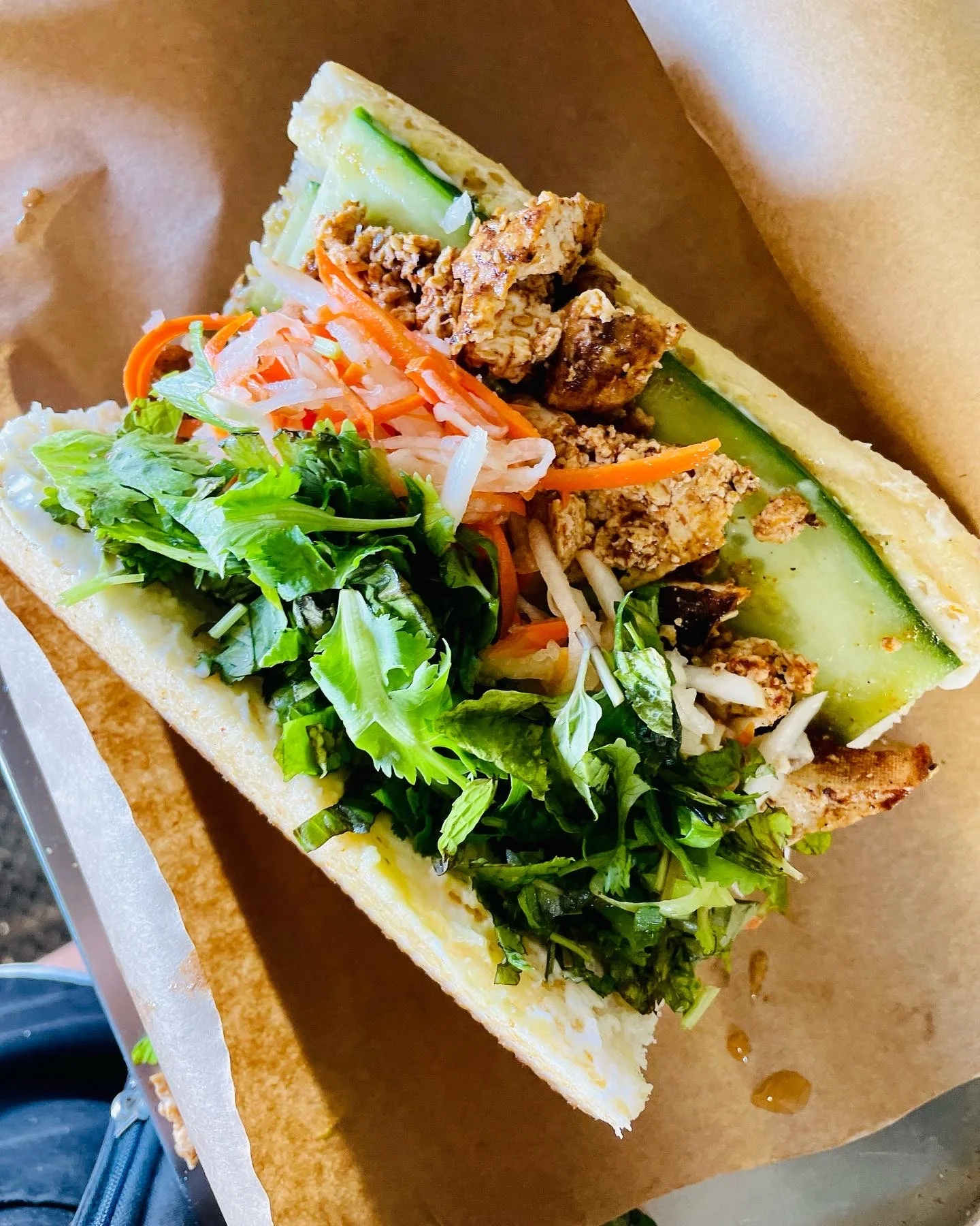 Vietnamese banh mi sandwich with fresh herbs and grilled chicken