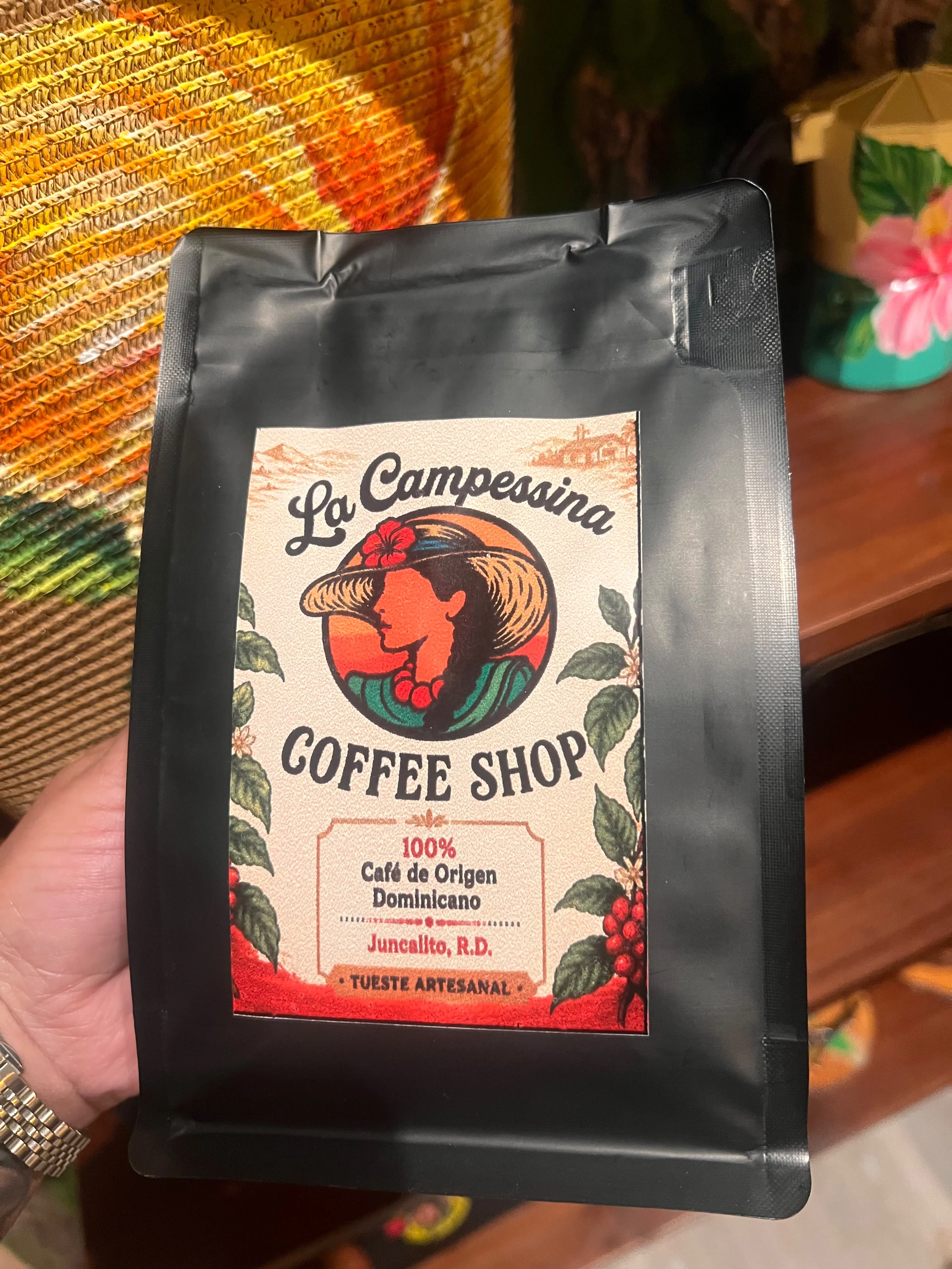 A close-up of a coffee bag featuring artistic packaging details, showcasing its origin and branding information, with a textured background.