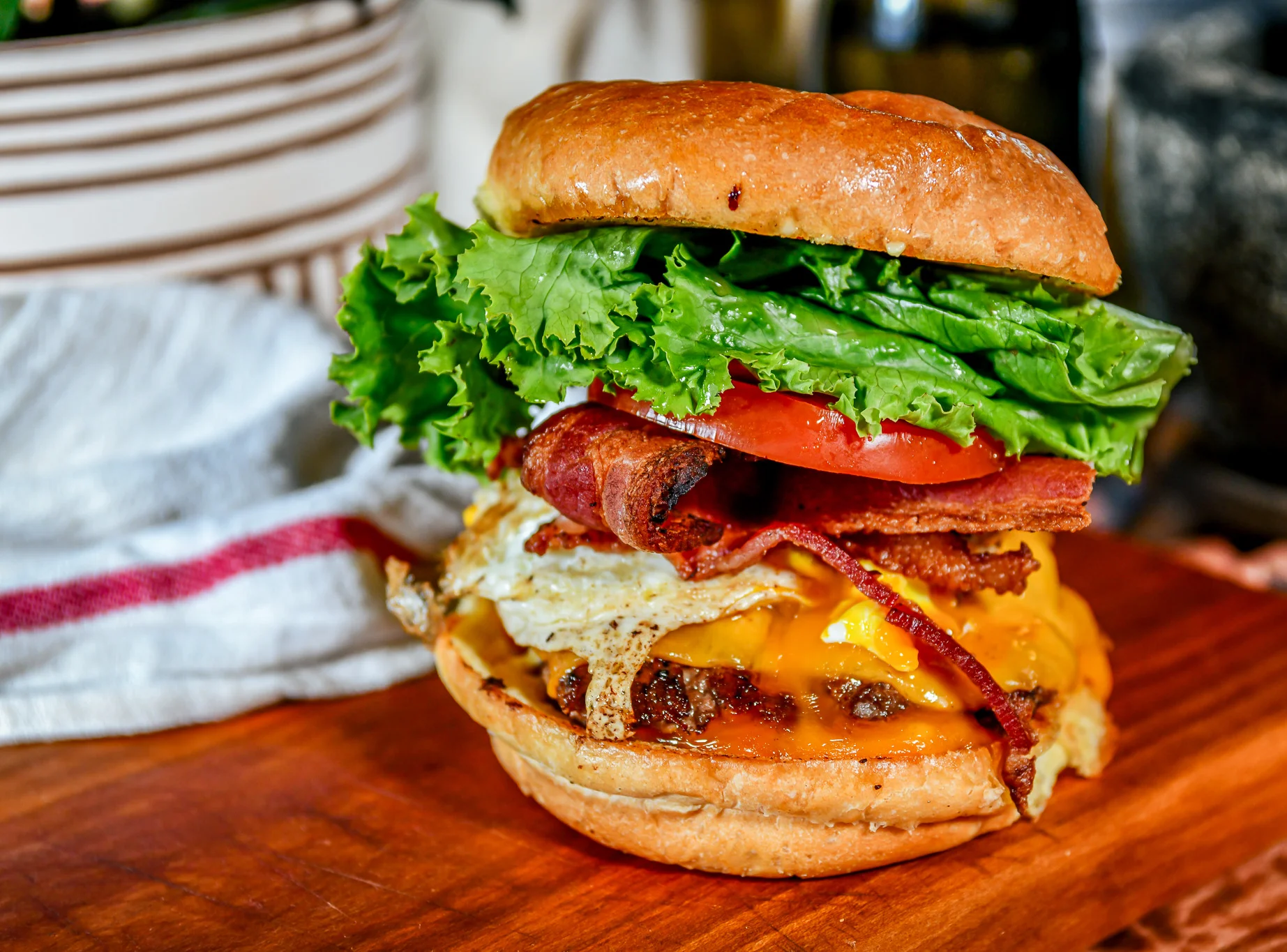 Sunrise Burger with lettuce, tomato, bacon, egg, cheese,