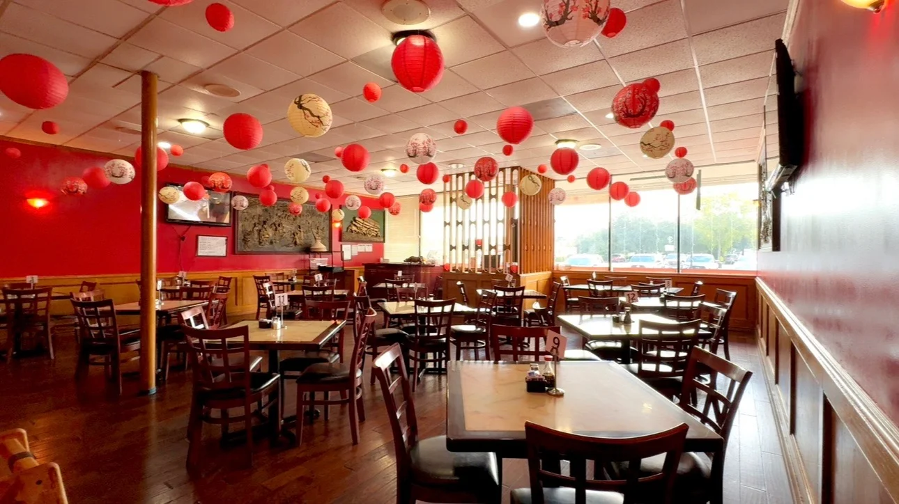 Cozy Asian restaurant interior with red lanterns and wooden tables