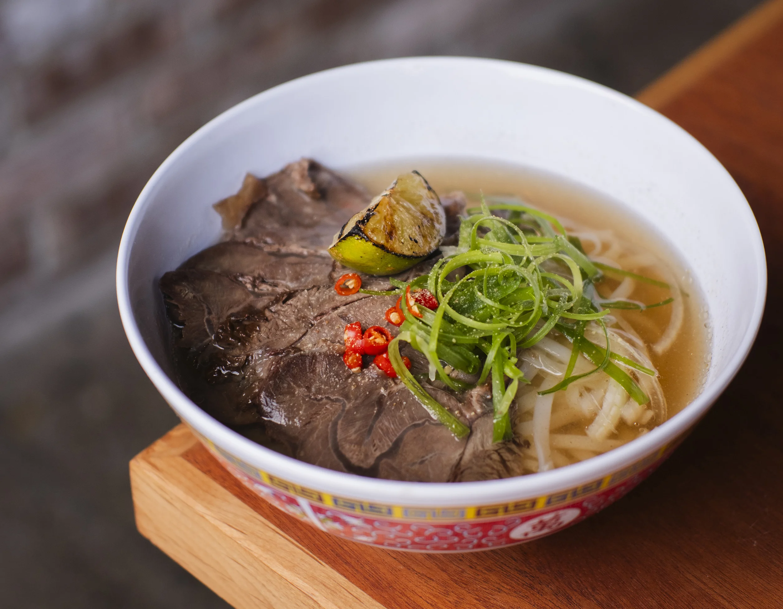 Bowl of Vietnamese pho with beef and fresh herbs