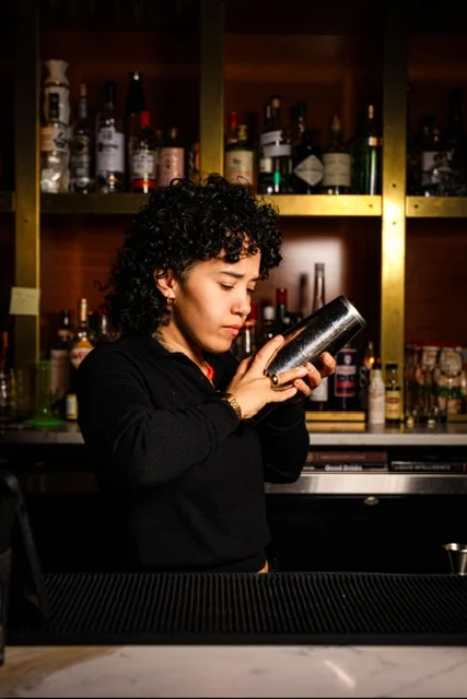 Bartender crafting a cocktail at a modern bar counter