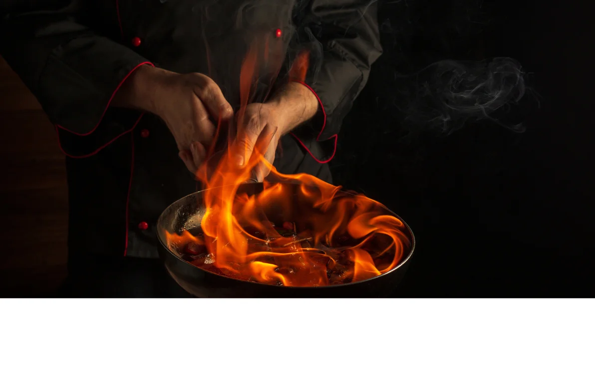 Chef flambéing ingredients in a pan